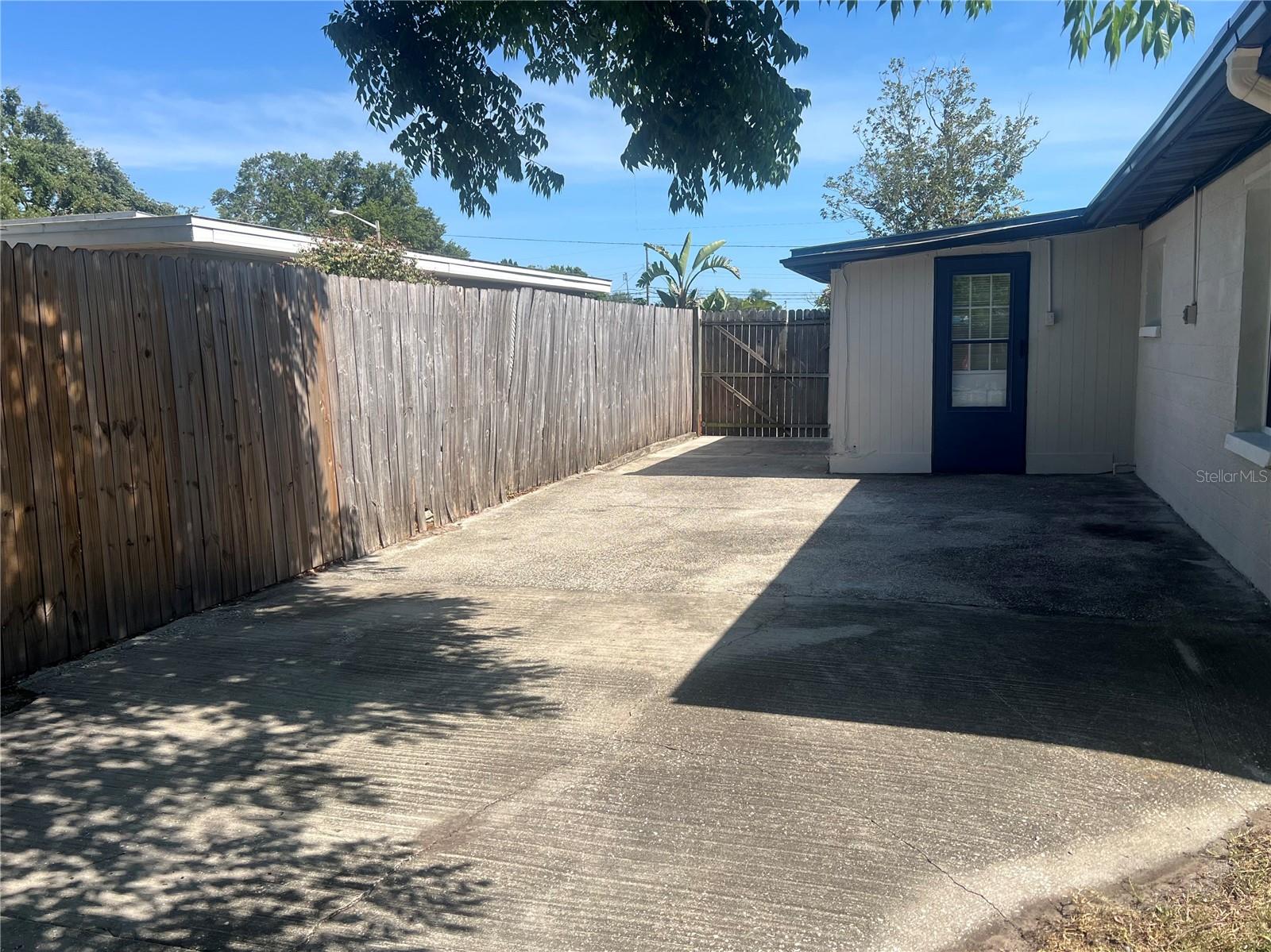 Large side patio with double gate to access the backyard