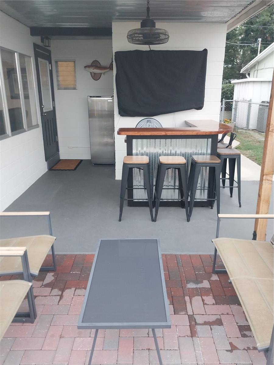 Custom backyard bar area provides shaded seating.