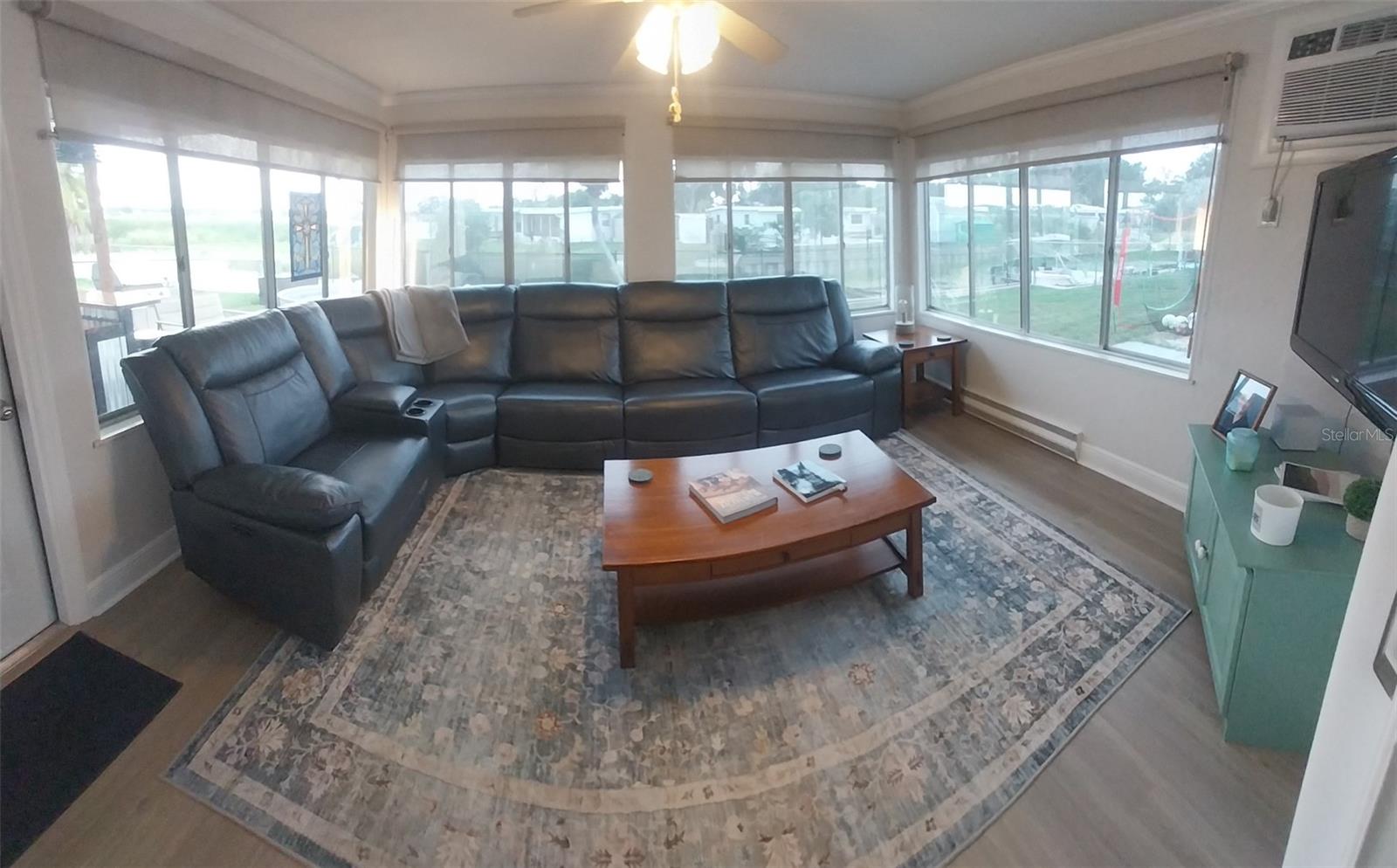 Living room in back of house has windows on three walls, with access to the backyard bar and pool.  Also has its own AC and can be closed off with sliding glass doors.