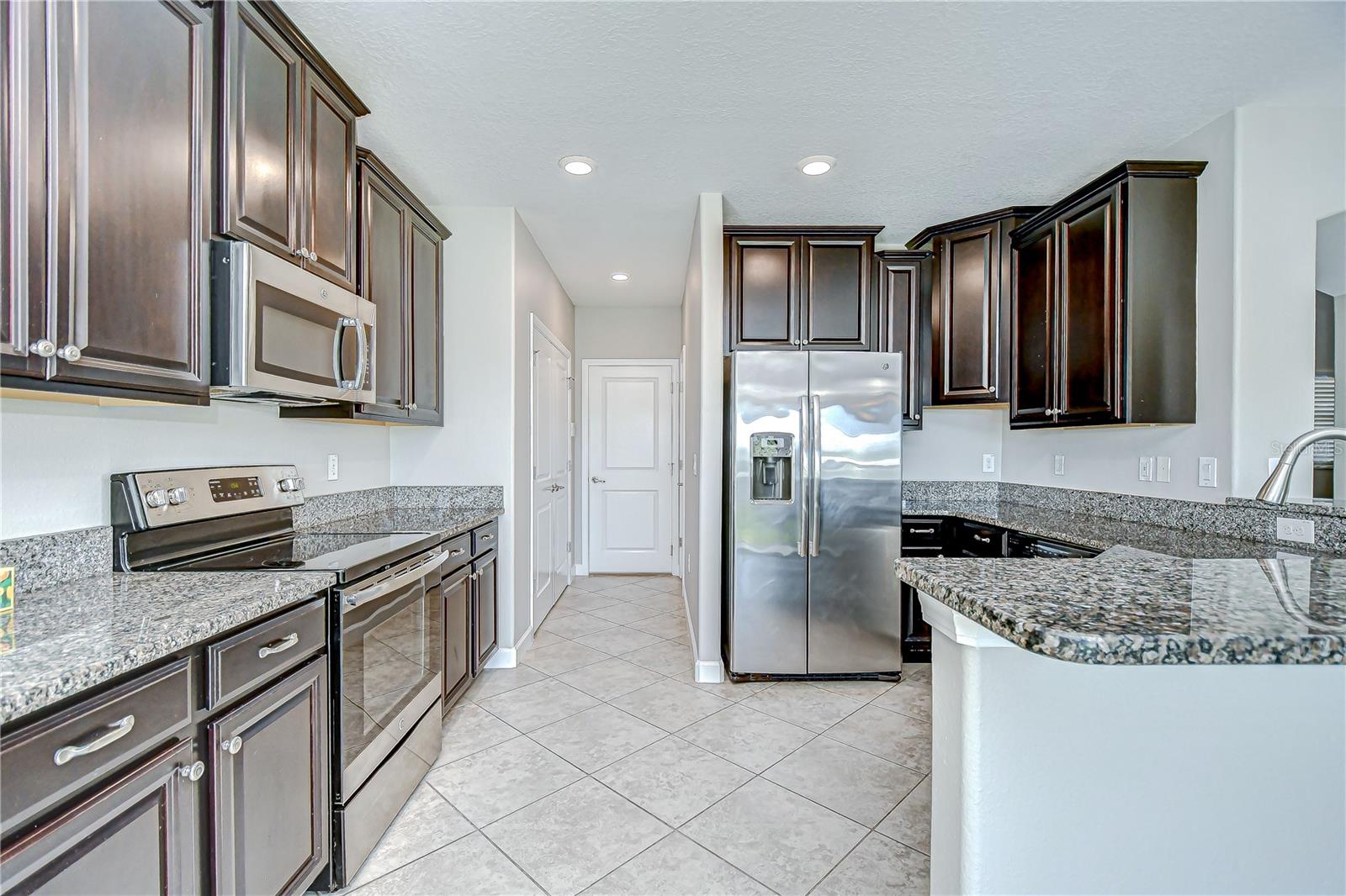 Kitchen features stainless appliances and rich wood cabinetry!