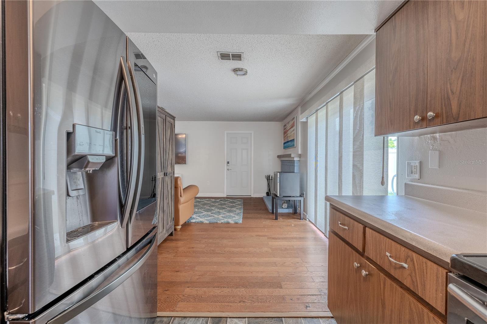 Updated stainless steel appliances, including a French door refrigerator and glass-top range, add modern convenience.