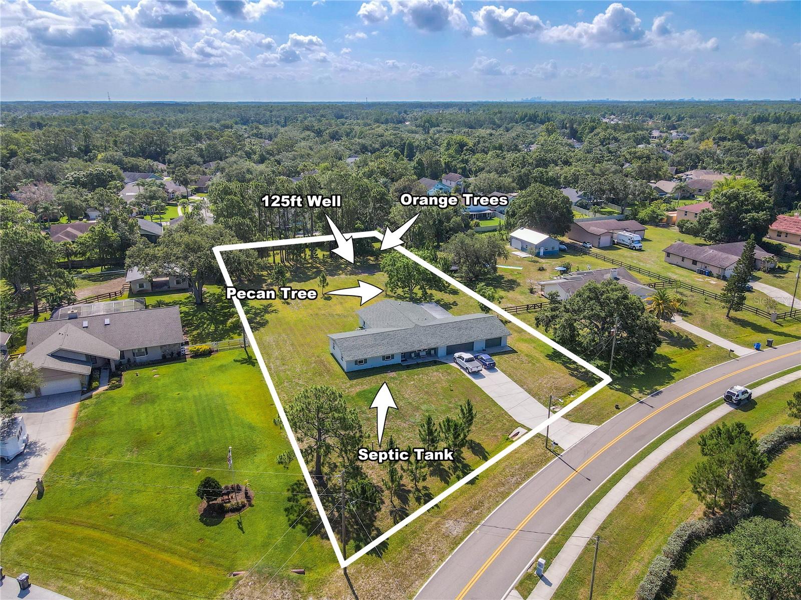 Set on a generous parcel with a long private driveway and expansive front lawn, this home boasts a deep 125-ft well and hurricane-rated double-pane impact windows throughout, providing peace of mind and energy efficiency.
