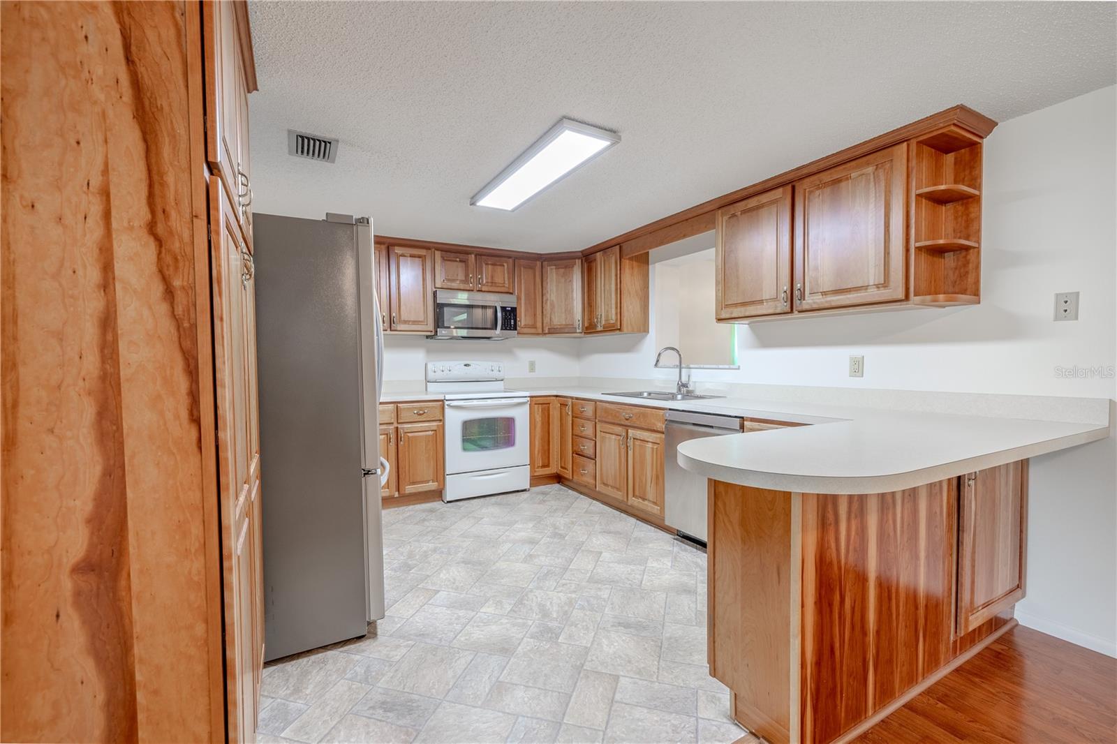 This well-appointed kitchen offers a warm and functional space with generous cabinetry, abundant counter space, and a thoughtful layout designed for everyday convenience.