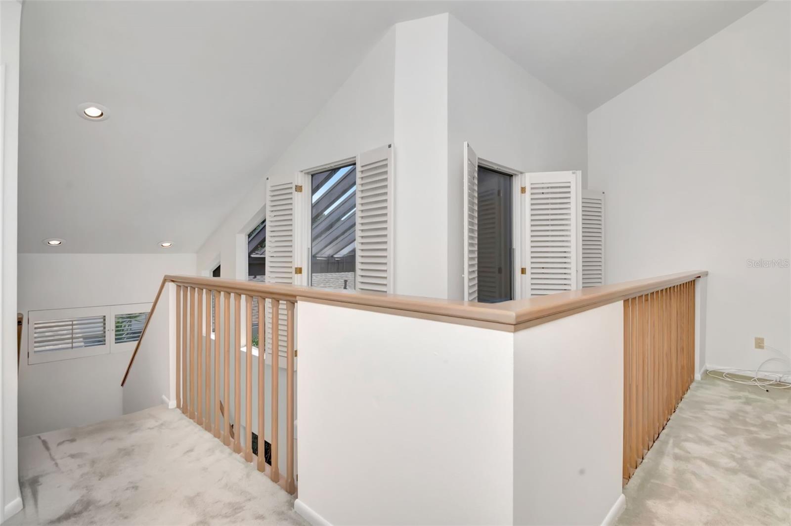 Numerous large windows, and vaulted ceilings provide light filled interior. This is landing to loft on second floor.