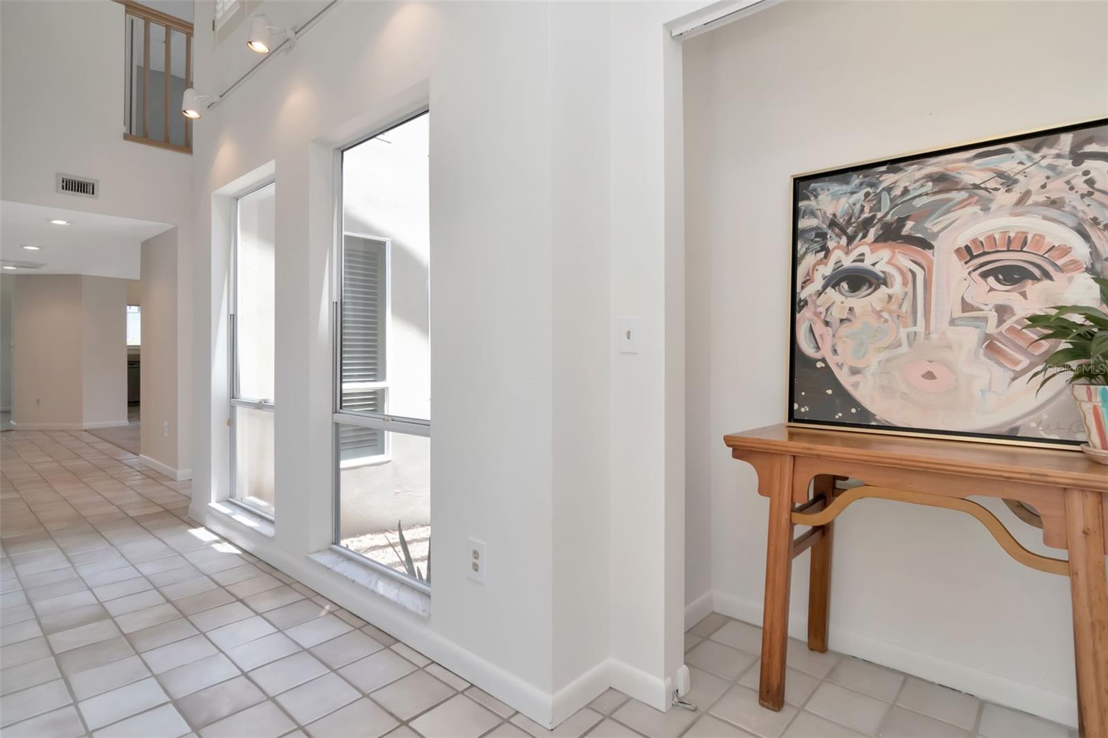 Entry hall overlooks atrium just waiting for your green thumb or doors to outside.