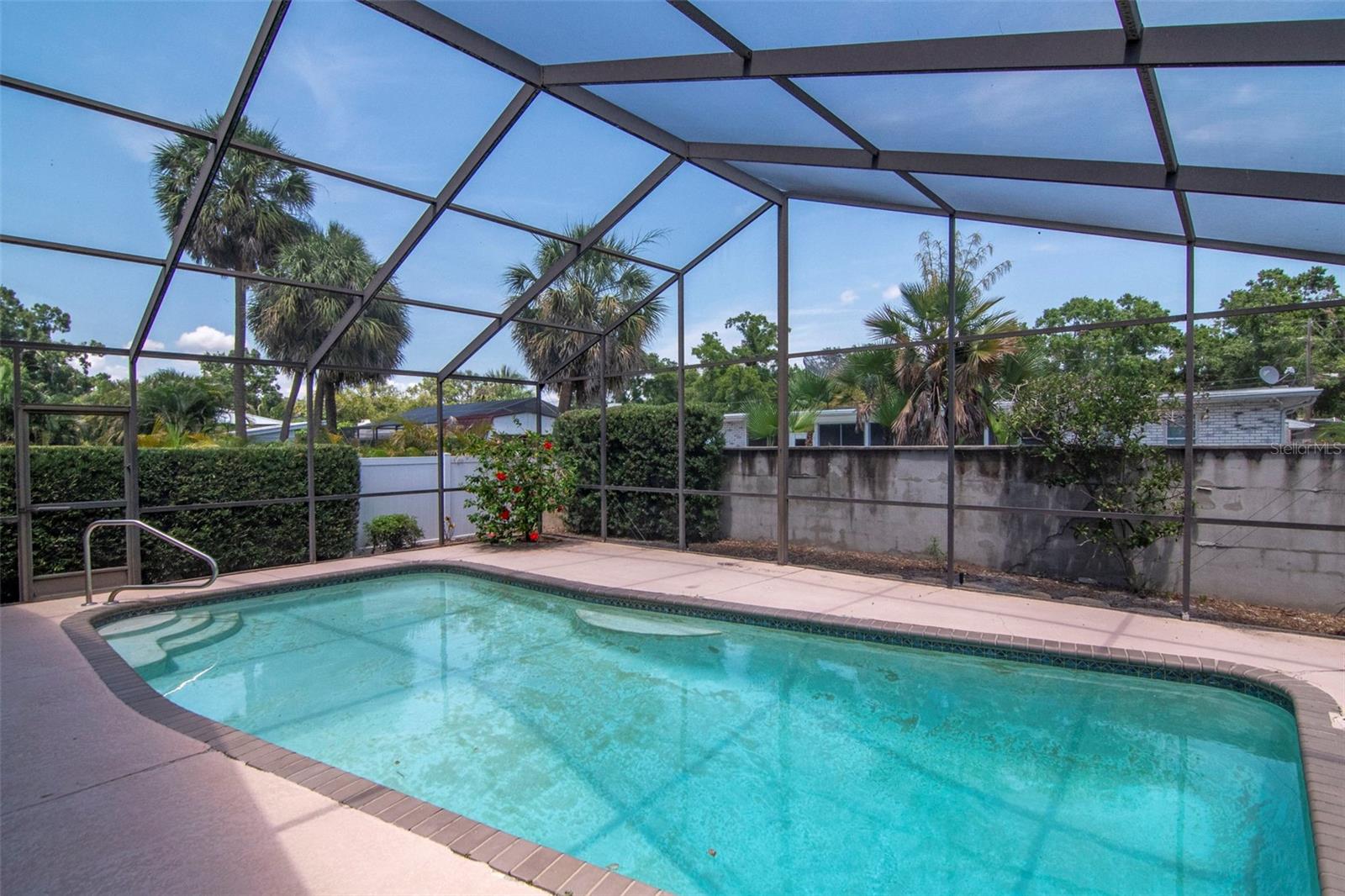 Heated, screened pool in a fenced and walled rear yard. Add landscaping to the irrigated yard to create your Florida oasis.
