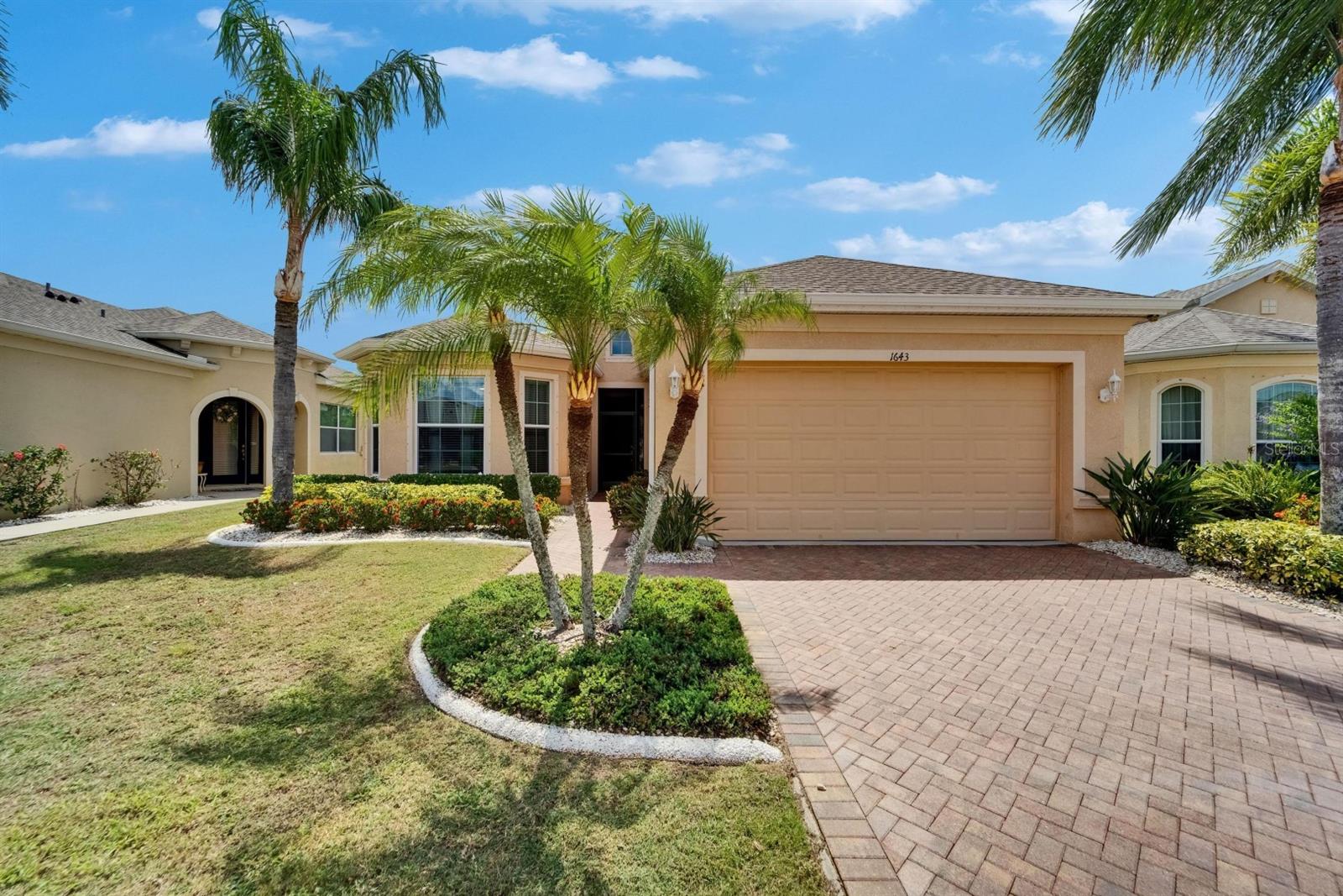Custom landscape curbing, swaying palms & pavered driveway
