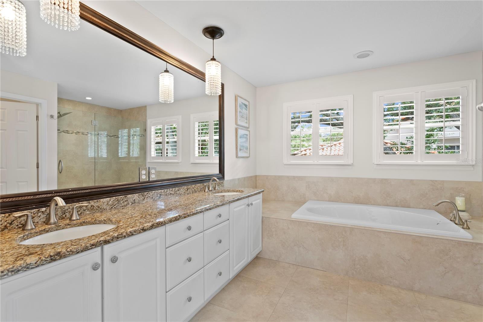 Retreat to the luxurious primary bath featuring double sinks, a large vanity and linen closet for extra storage.