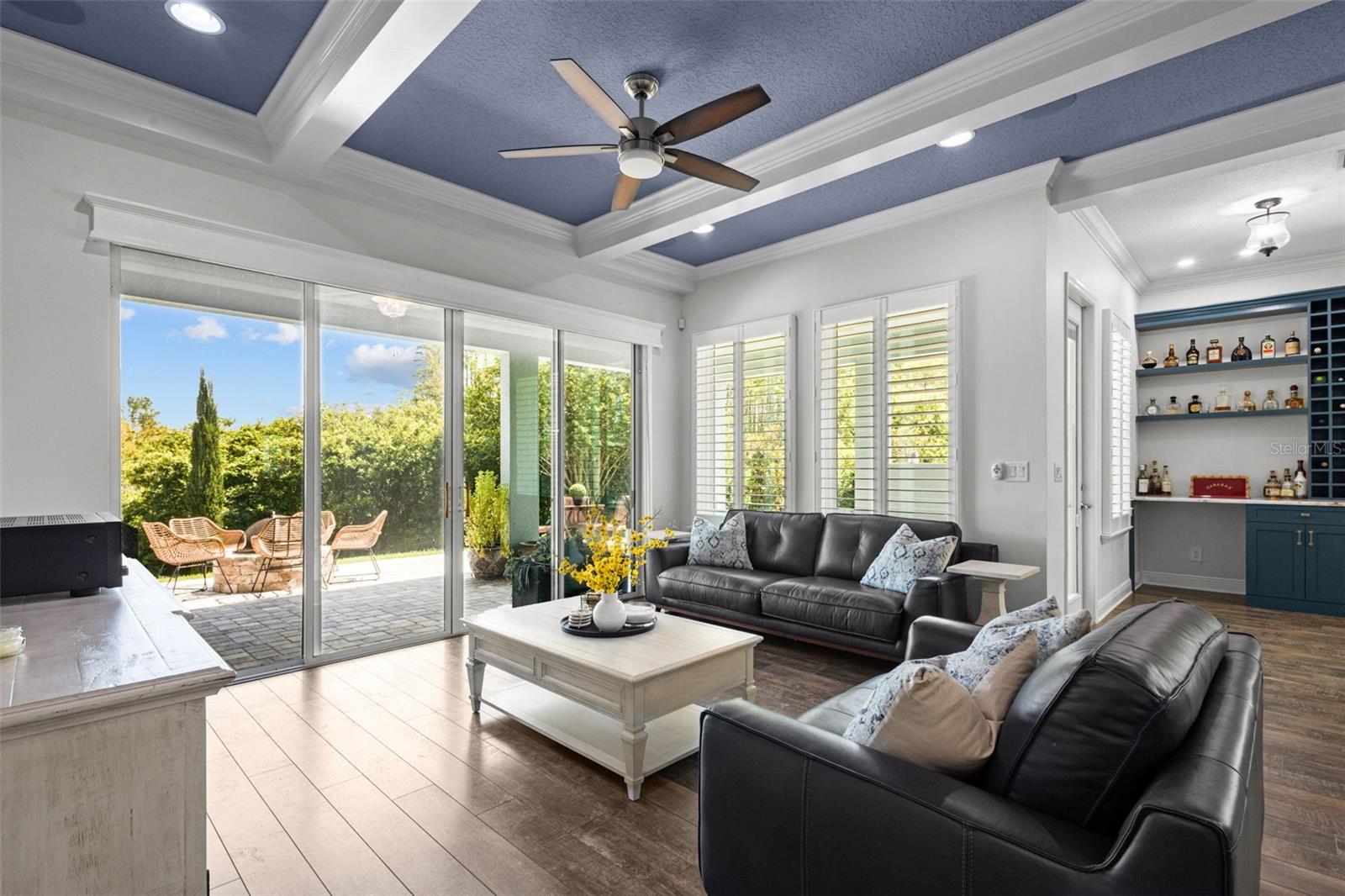 Living Room with exposed beams, plantation shutters, and view of the conservation