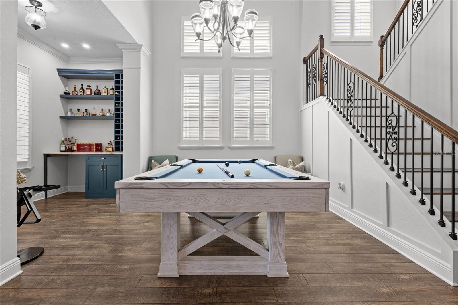 Dining Area with built in bar, upgraded stair railing, and tall ceilings fully open to the 2nd floor