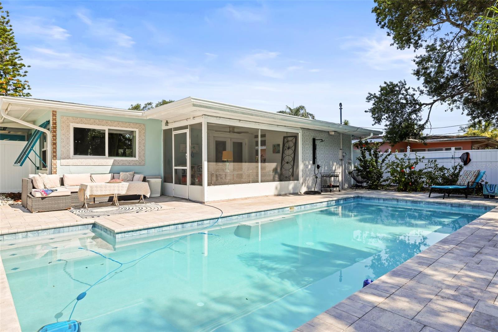 Stunning back yard space with screened lanai, outdoor shower and sparkling pool