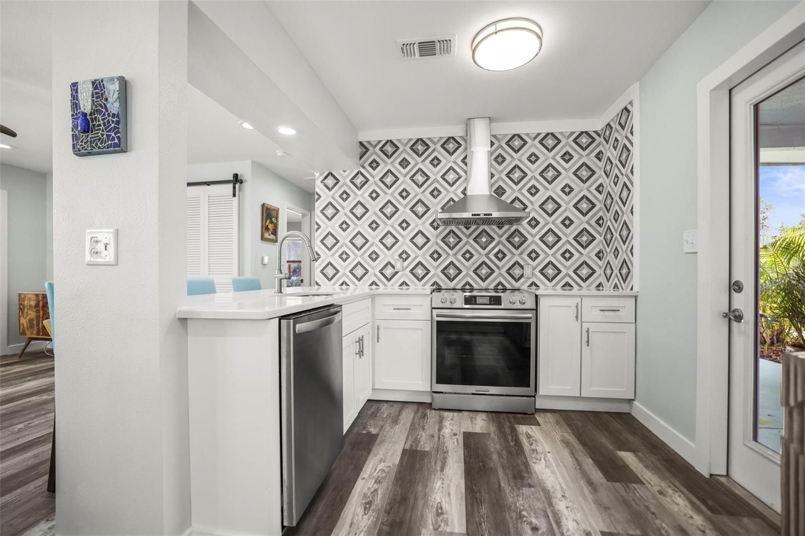 Kitchen - Quartz Breakfast bar, beautiful wall of tile open to the living room