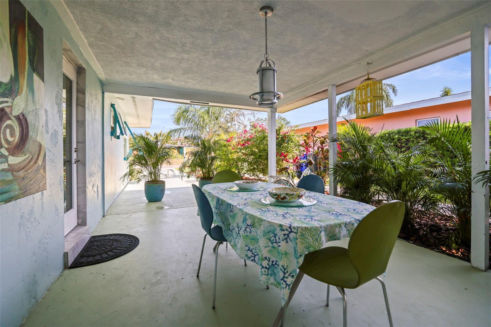 under cover entertainment spot with lush landscaping, right outside the kitchen