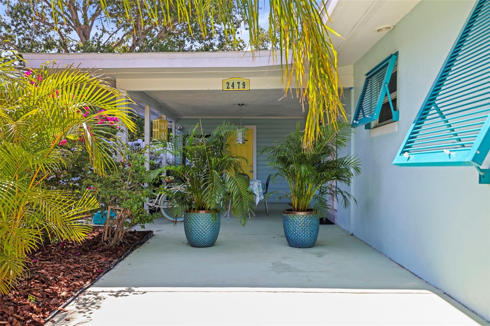 Entrance and outdoor space. Afternoons breezes while under. Fun Bahama Shutters really pop on this home.