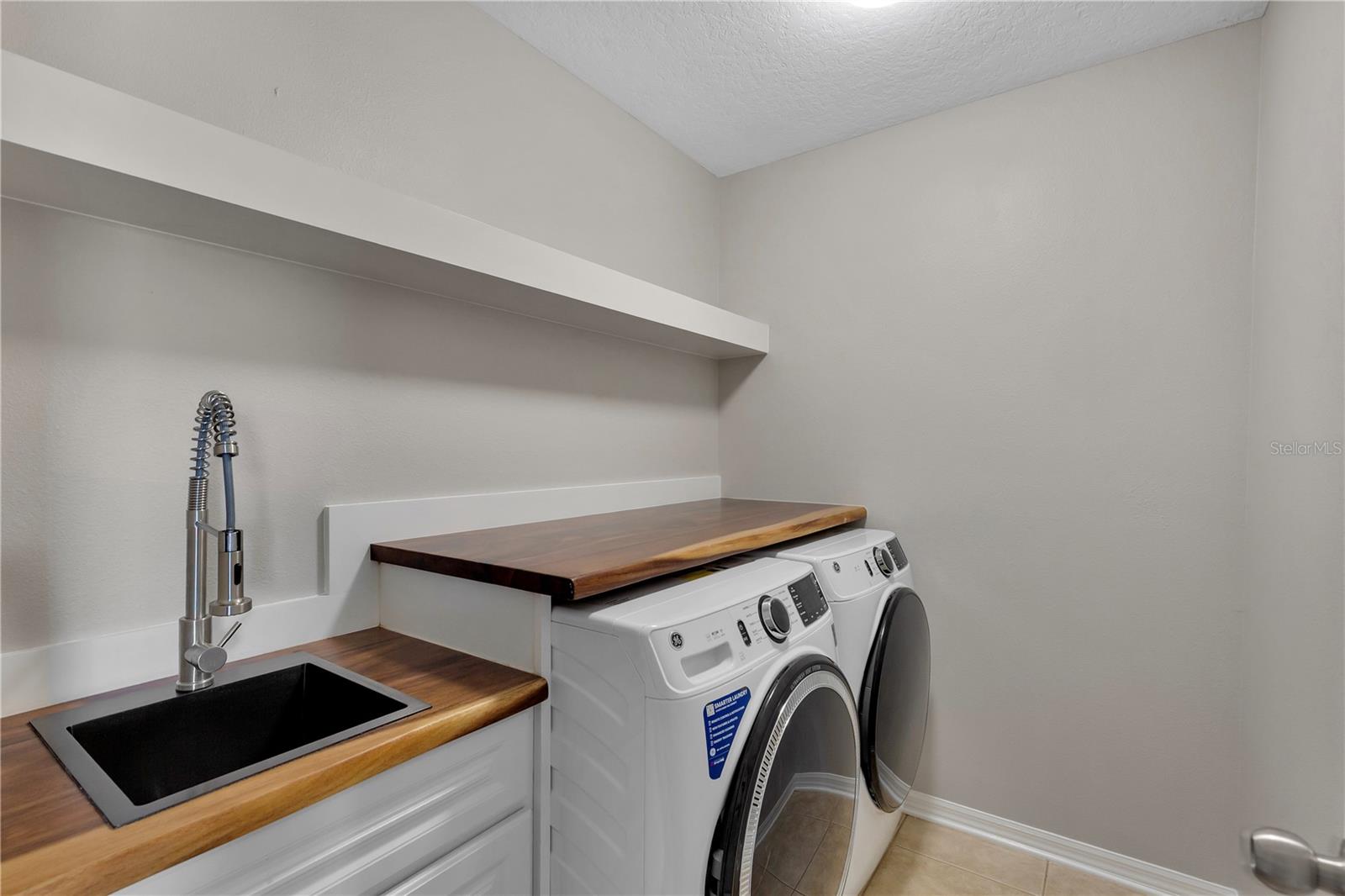 Oversized 2nd floor laundry room with custom folding table and sink