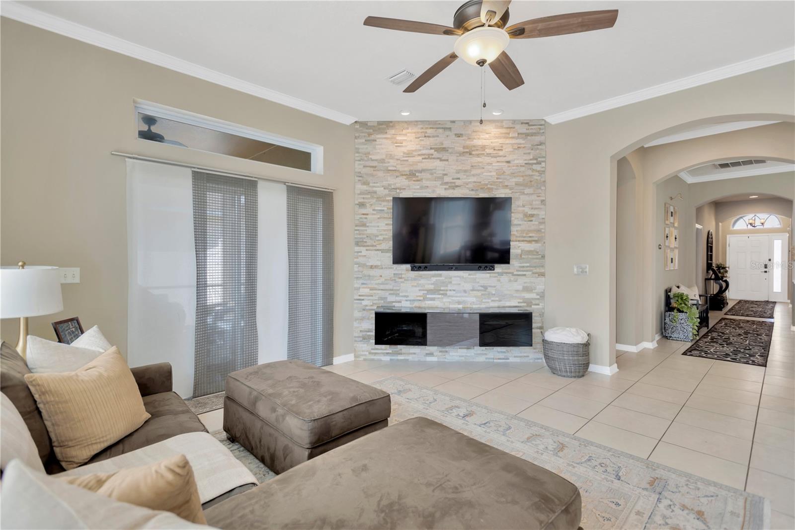 Comfortable and inviting family living area ~ great for just relaxing or entertaining.  Notice the artistic focal point ~ stunning stone wall that is home to your TV entertainment center.