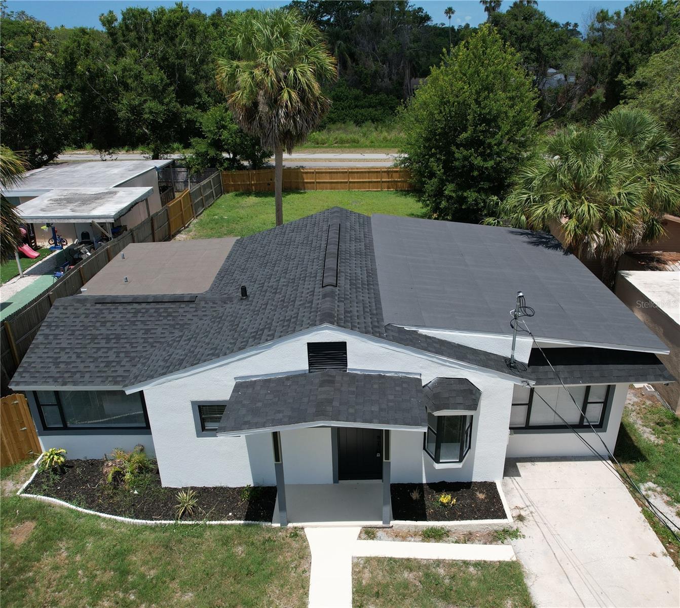 Front of home with fenced backyard showing and Pinellas Trail just beyond fence.