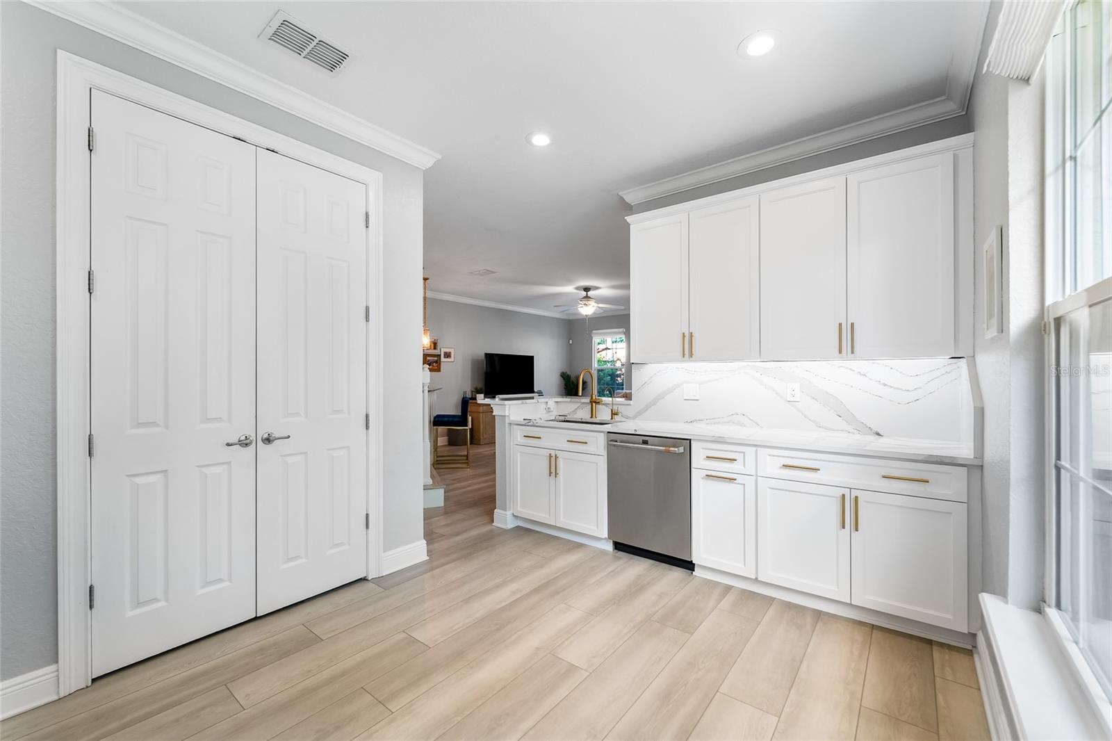 Huge kitchen from the frig showing the pantry closet and amazing floors.