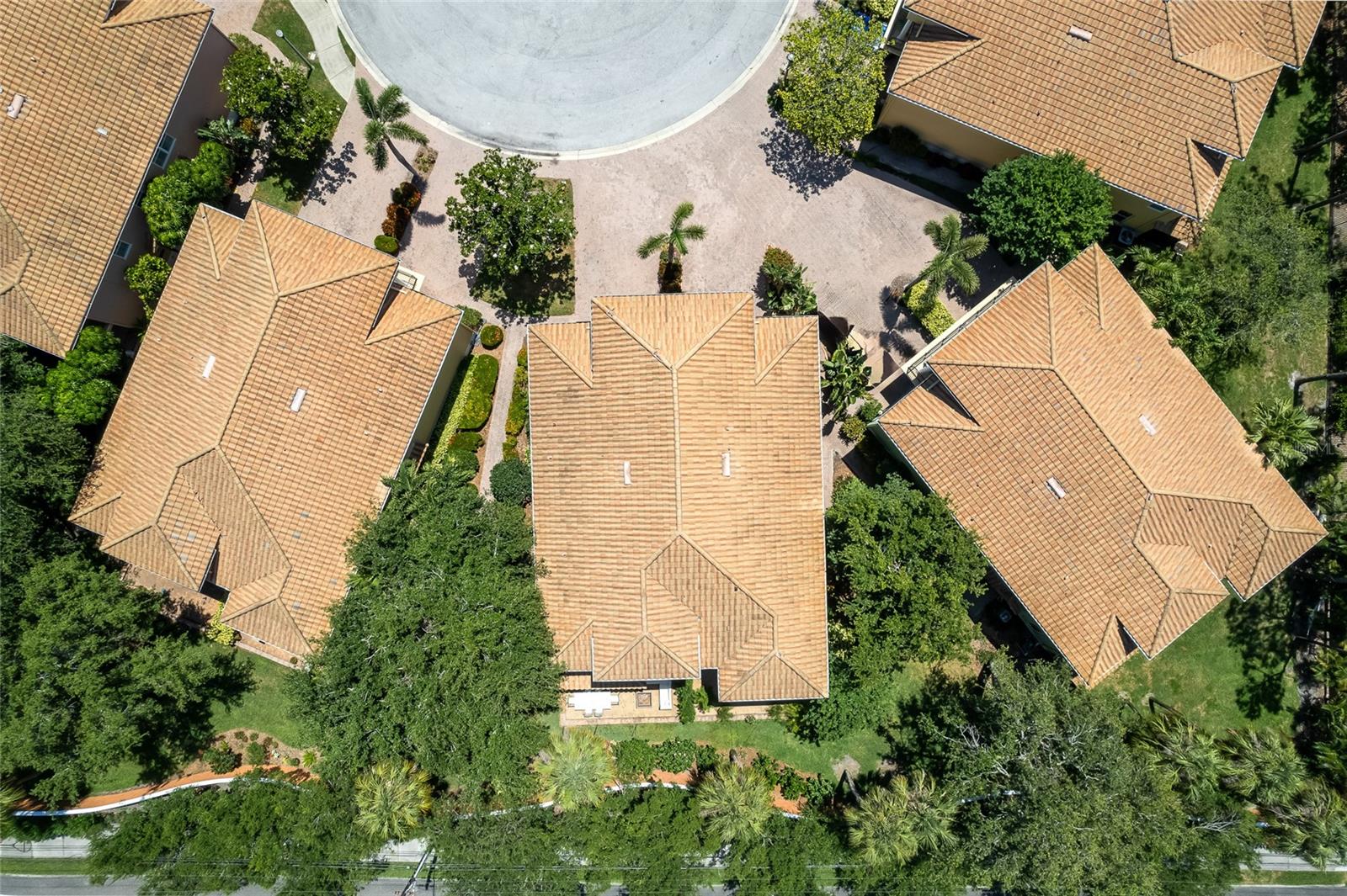 Mature landscaping, brick pavers and concrete tile roofs.