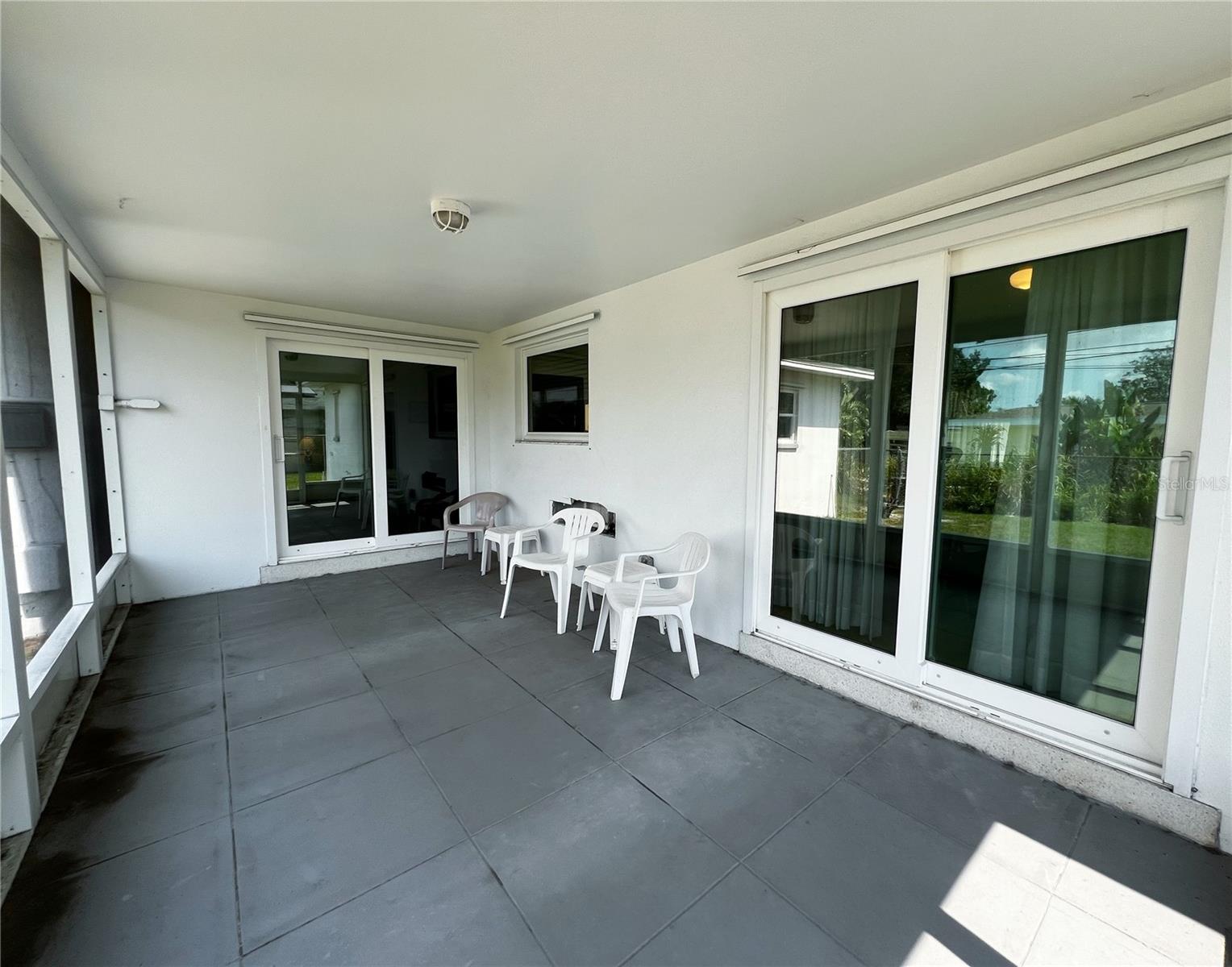 View of the porch and two accesses- one off the dining area, one off the family room. Newer impact sliders.