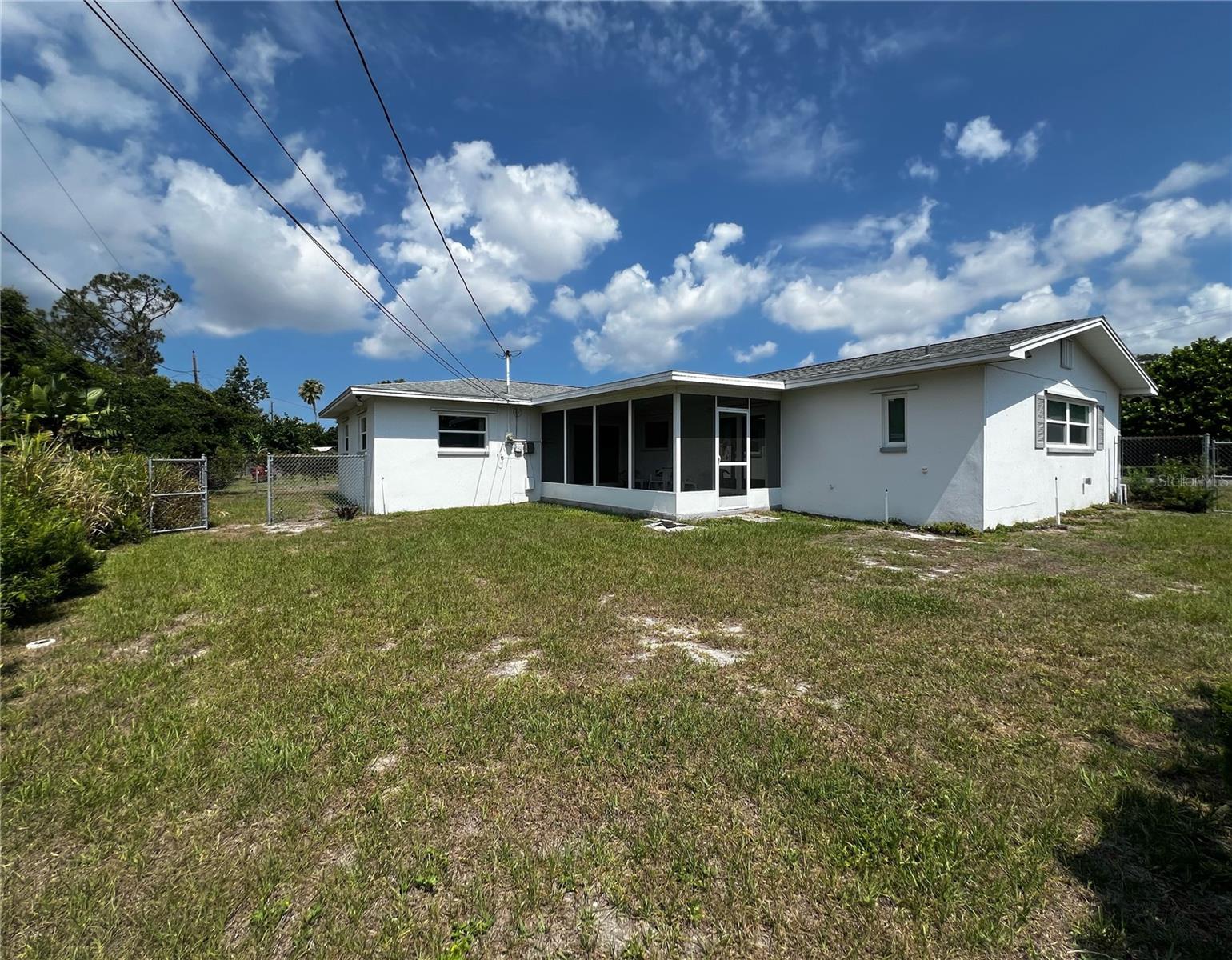 Back of the home, porch, and look at the spacious yard.