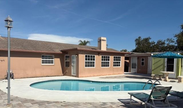 Back Exterior with pool and new pavers and storage