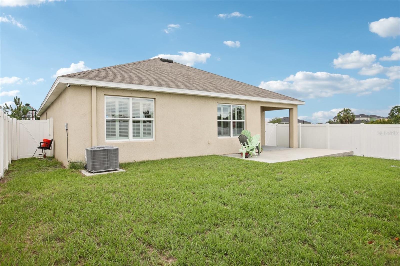 Fully fenced yard with extended concrete patio