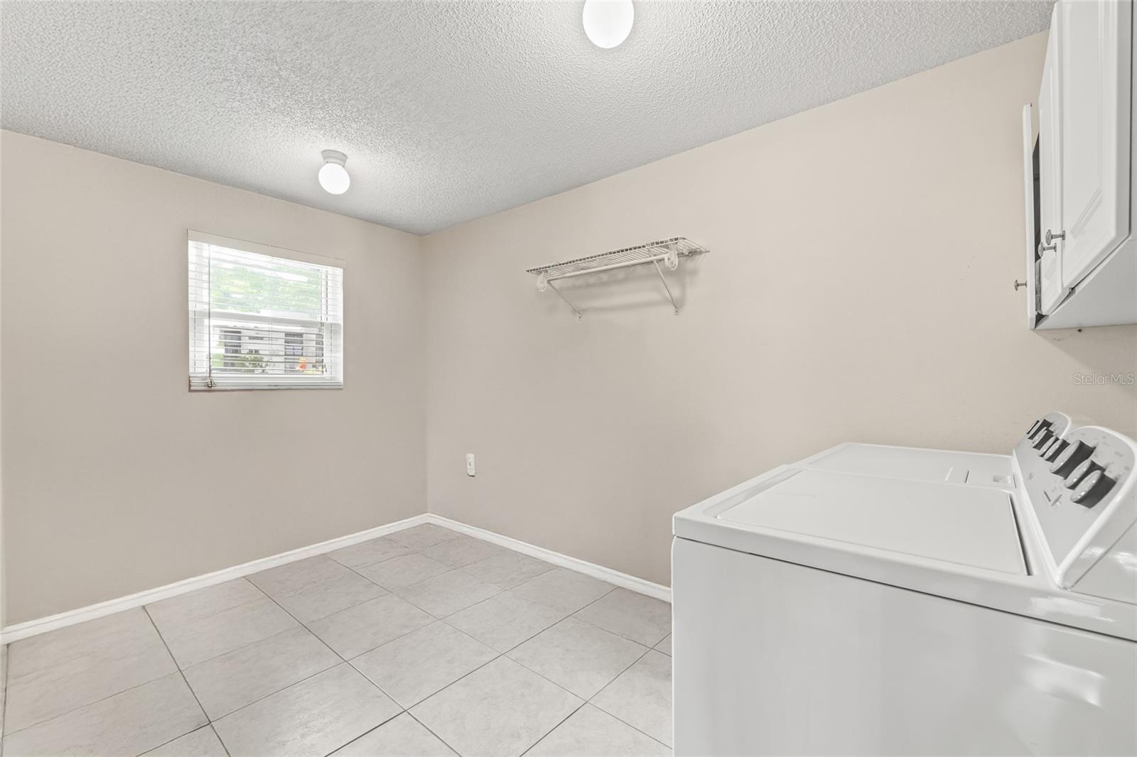 Digitally removed items in oversized private laundry room.