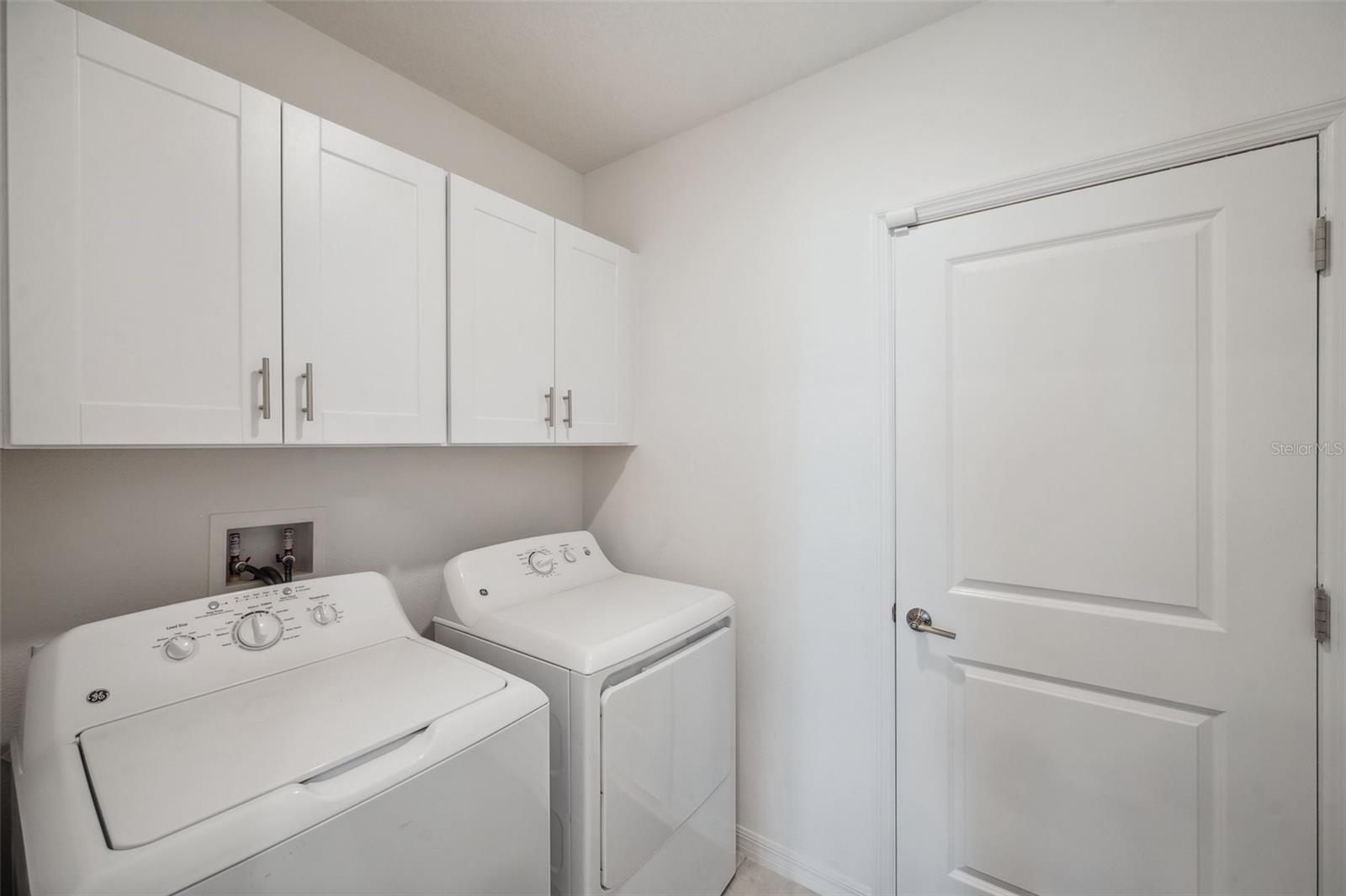 Inside laundry room with cabinets
