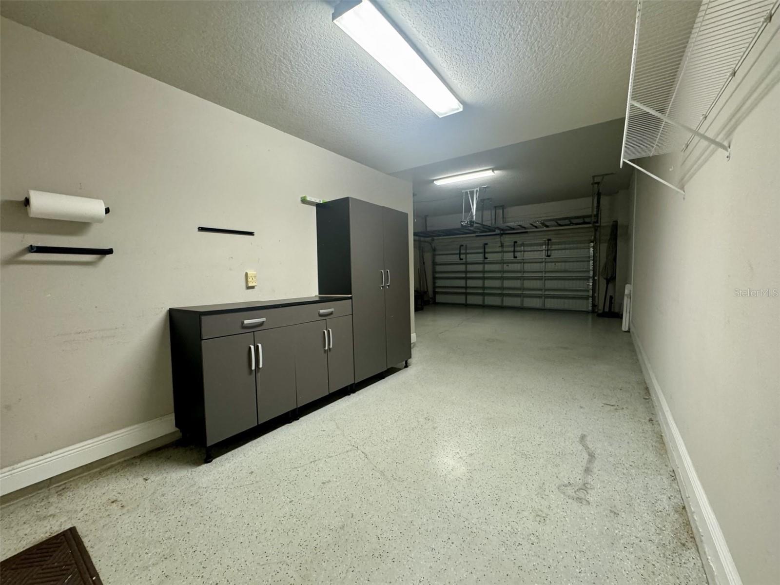 3 CAR TANDEM GARAGE WITH STORAGE CABINETS AND HANGING SHELVES