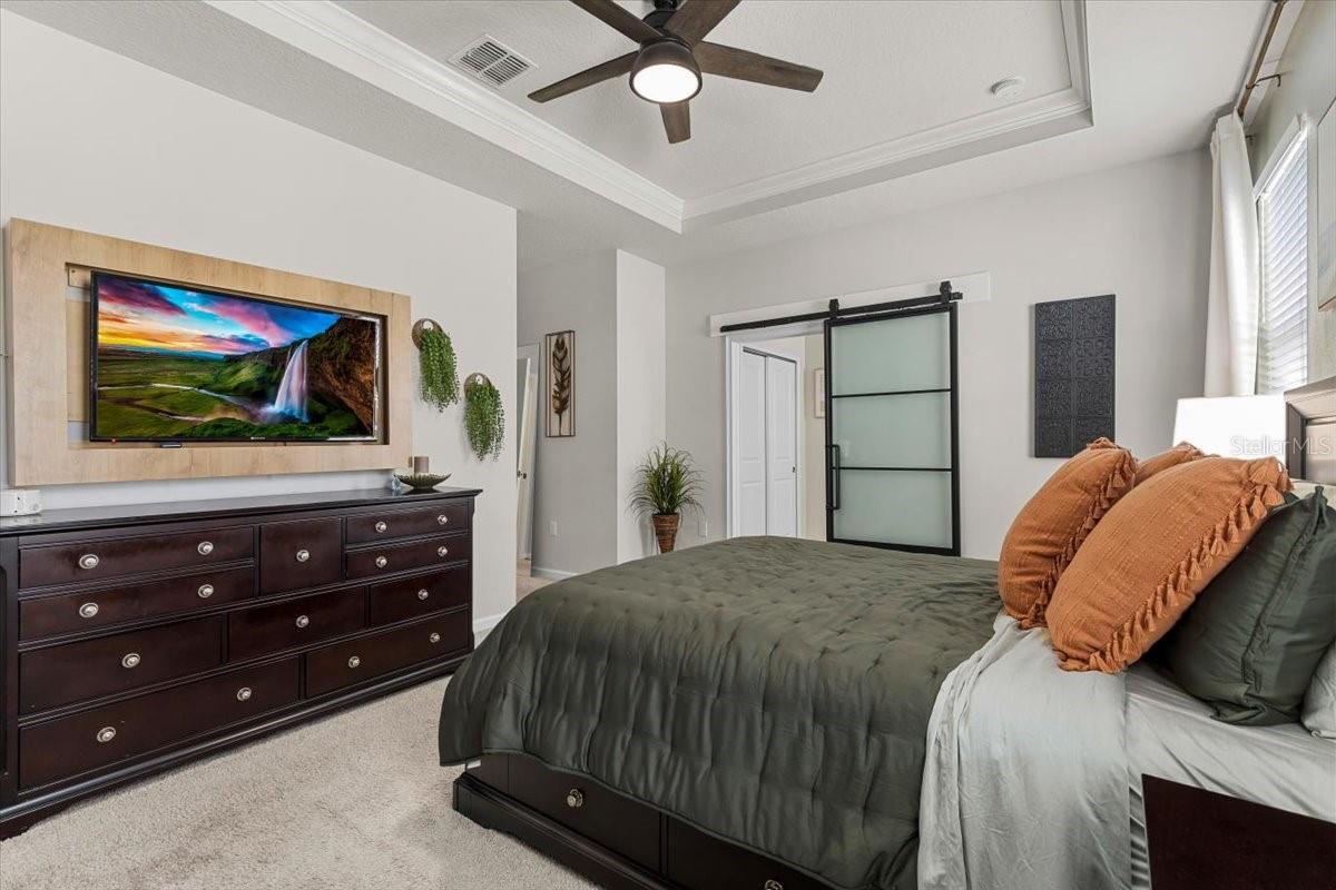 Primary suite with glass barn door to primary bathroom