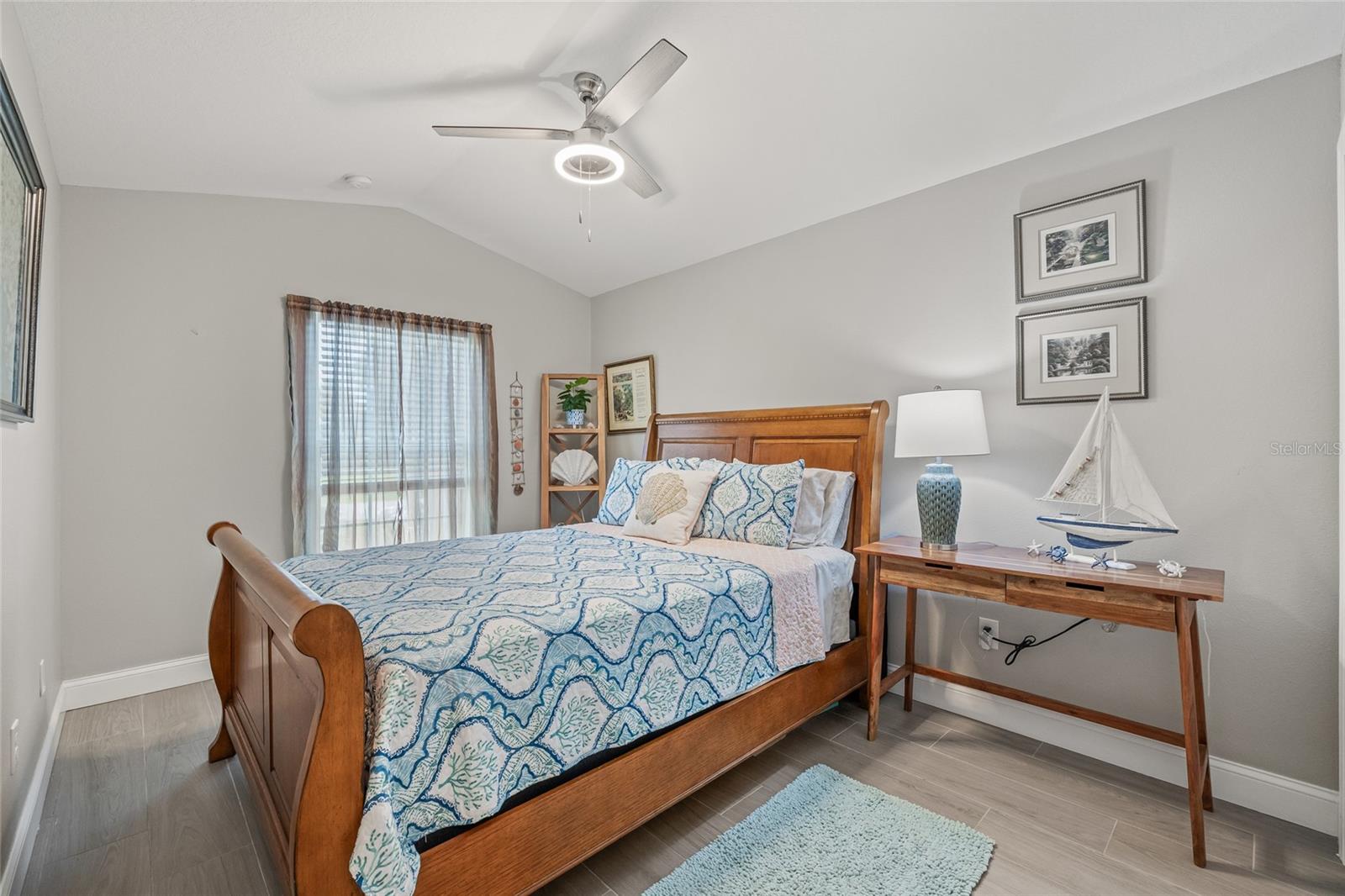 This charming bedroom features soft natural light, calming tones, and a ceiling fan for year-round comfort—perfect for guests or family.