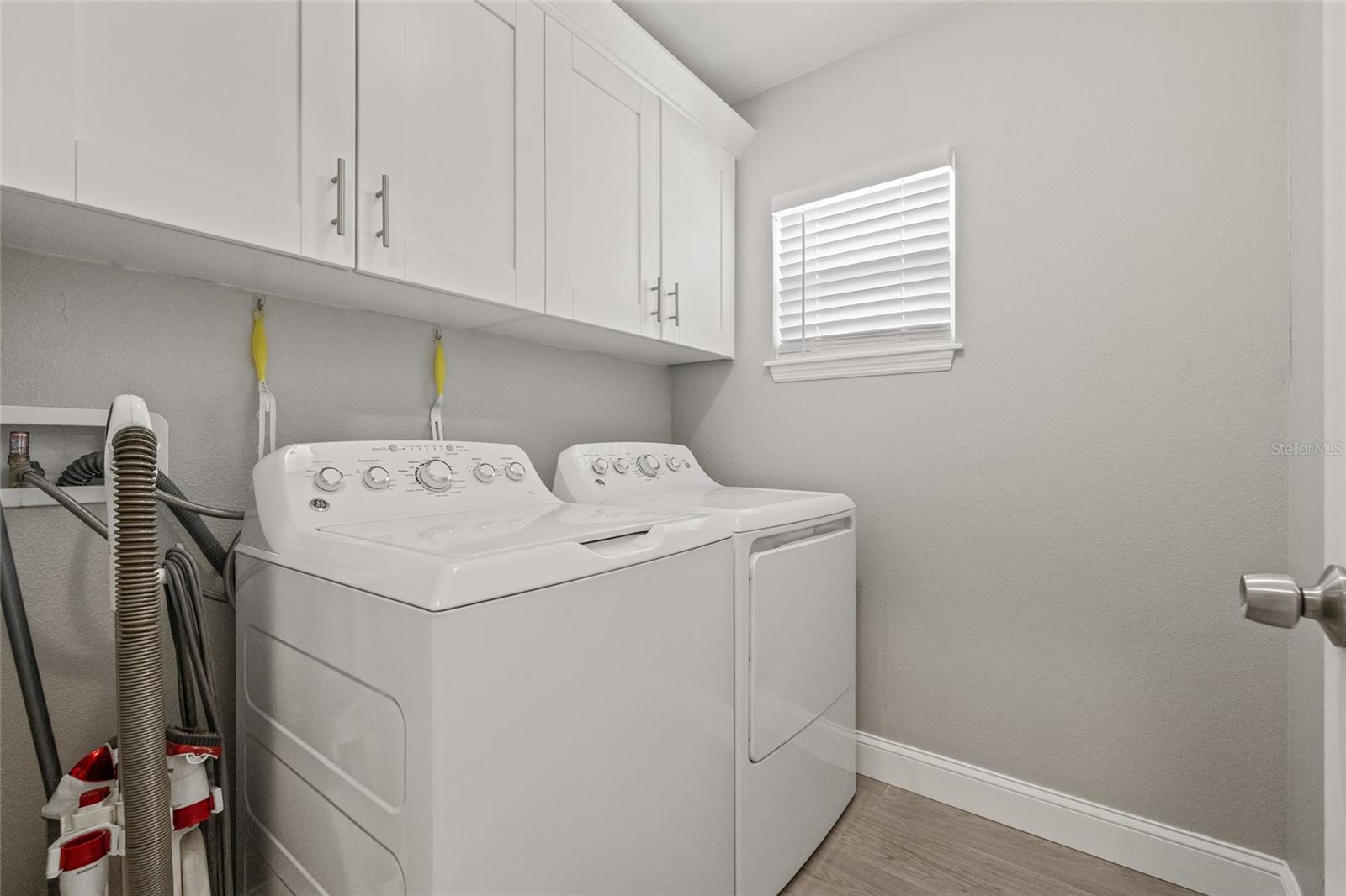 Convenient indoor laundry room with 2022 washer and dryer, ample cabinetry, and smart organization—designed to make laundry day a breeze.