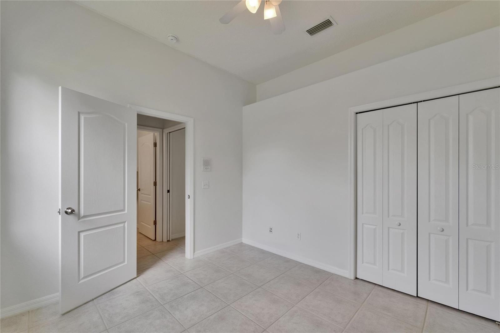 Bedroom 4 looking to Bathroom 3 and slider door in hallway
