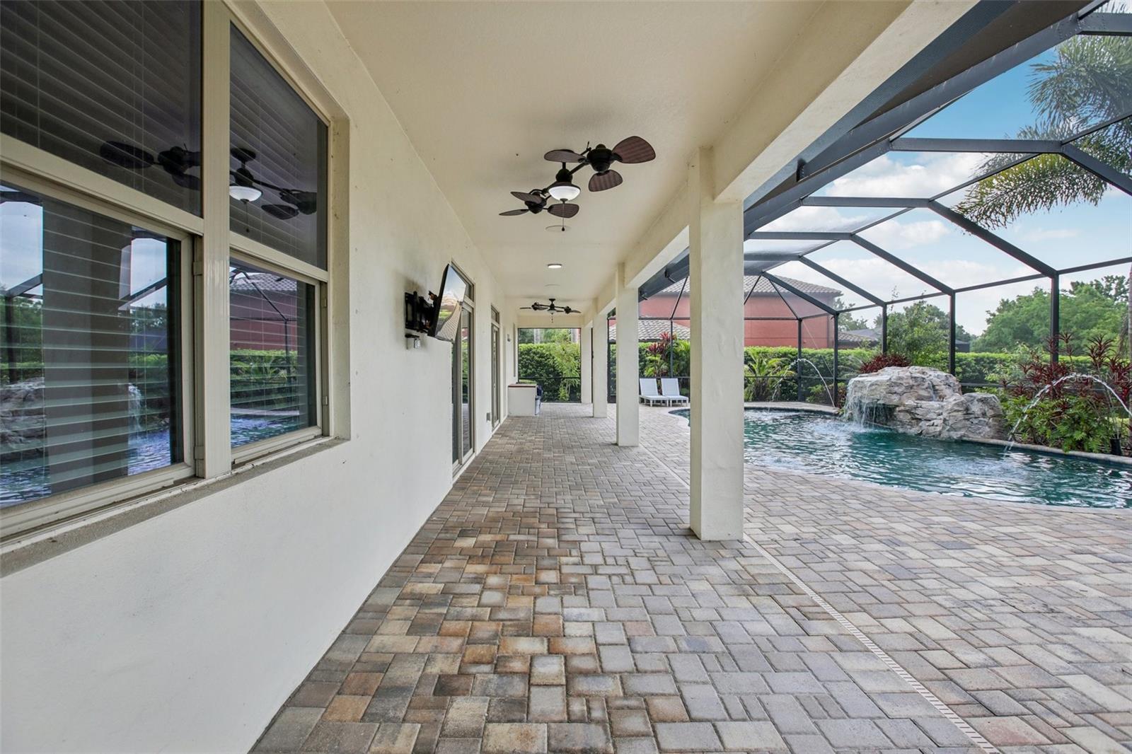 Tropical pool with waterfall and lanai