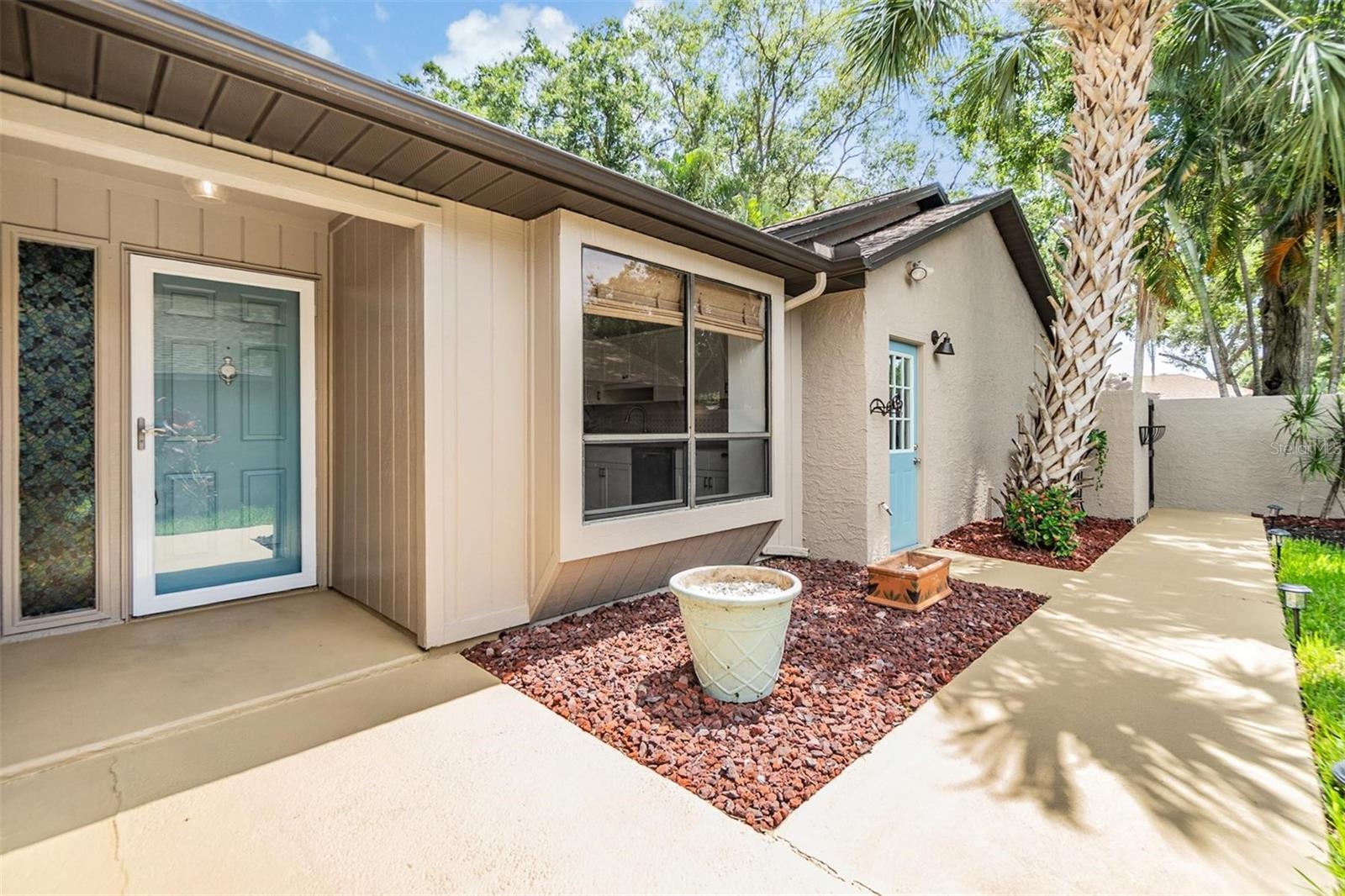 Front door and side garage door in courtyard entry way