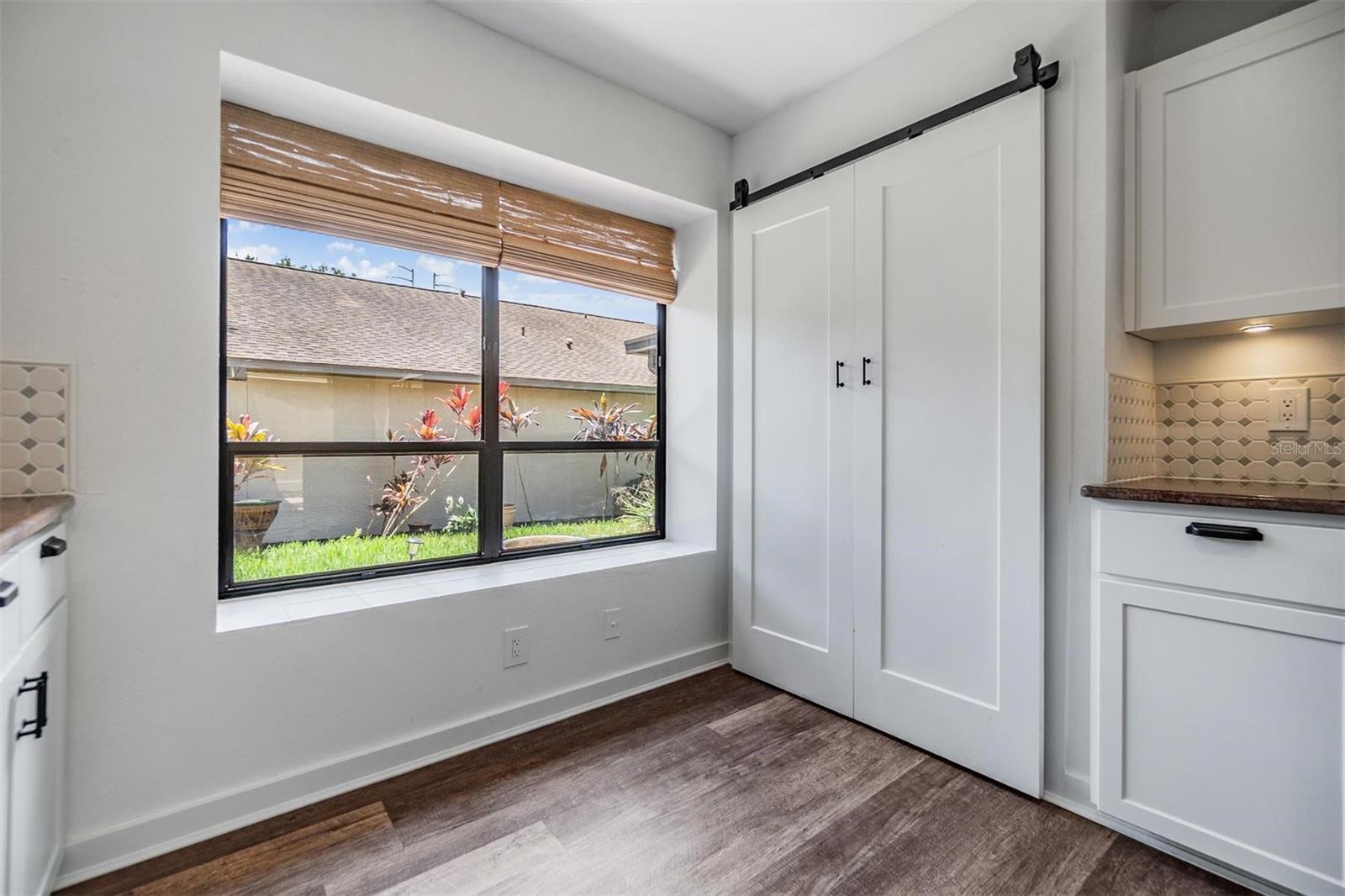 Updated kitchen with all stainless steel appliances, granite countertops, bright white modern cabinets, a pantry, and passthrough window to the dining room.