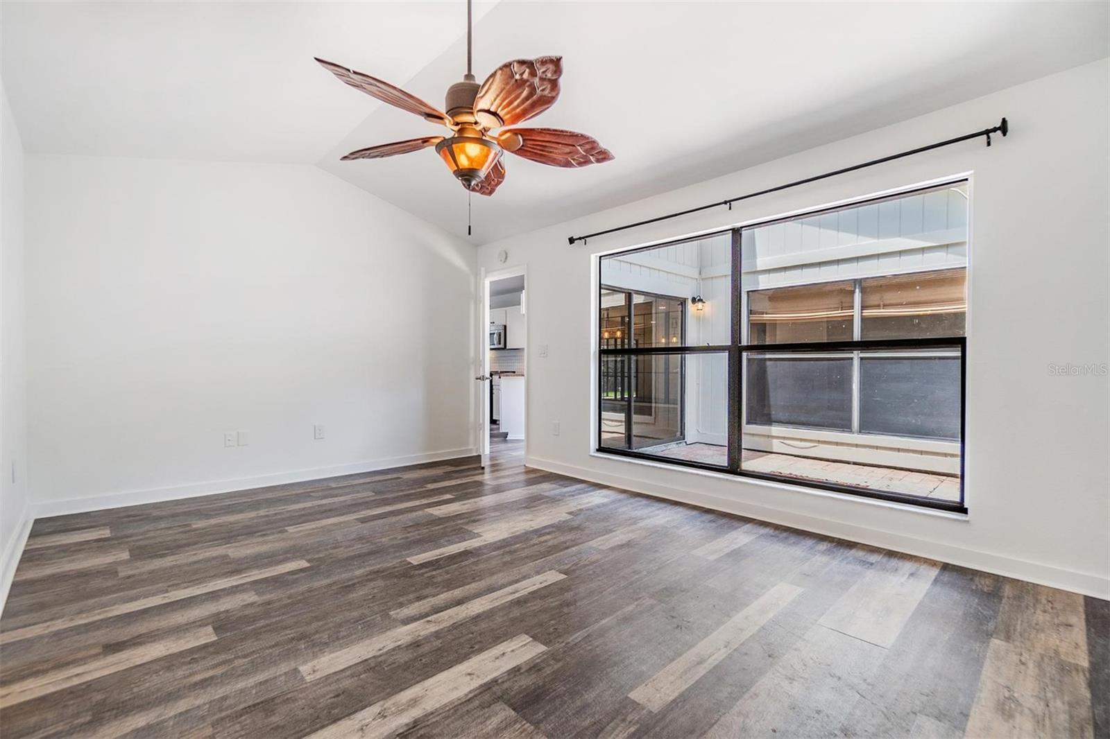 Spacious primary bedroom suite with vaulted ceiling, large wall of window to atrium, ensuite bath with updated dual sink vanity, with granite countertop, tile walk-in shower, huge walk-in closet.