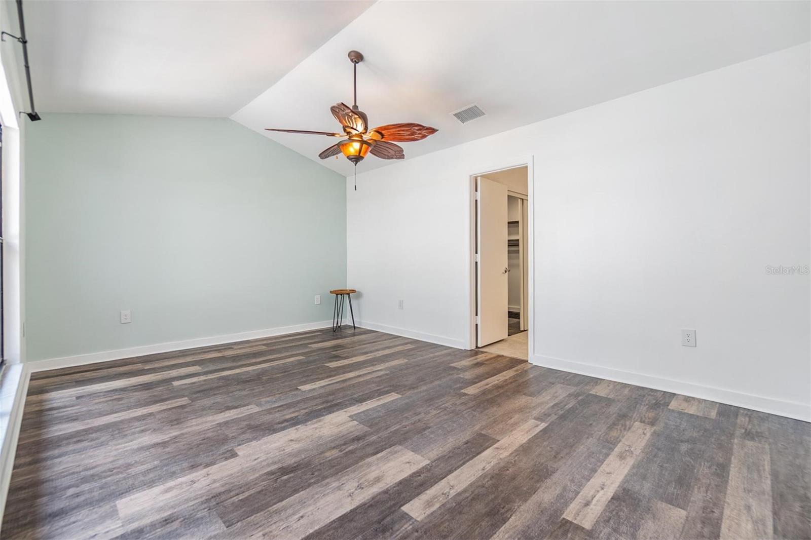 Spacious primary bedroom suite with vaulted ceiling, large wall of window to atrium, ensuite bath with updated dual sink vanity, with granite countertop, tile walk-in shower, huge walk-in closet.