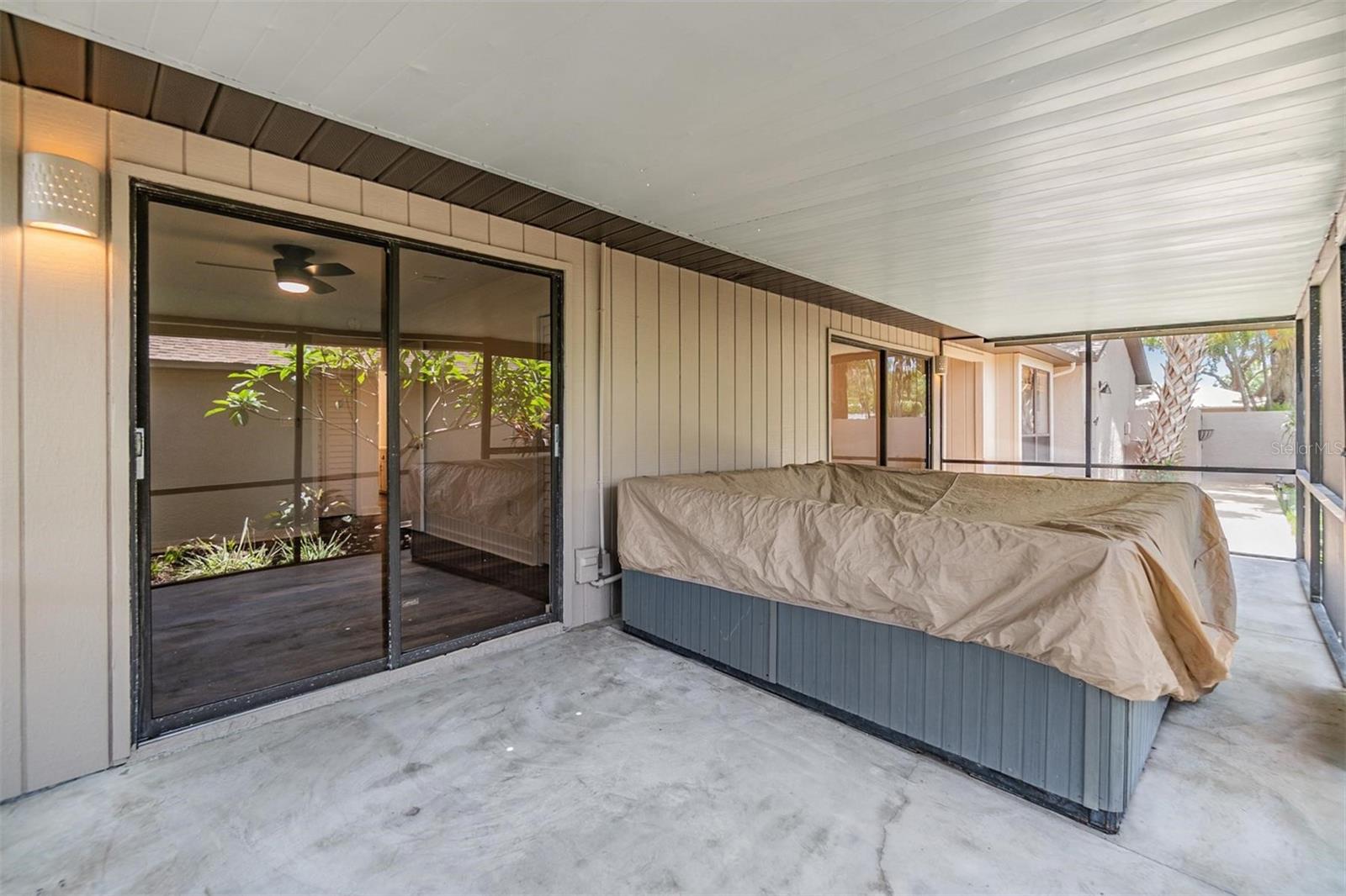 Screened-in patio with access from the 2nd bedroom and dining room large enough for table, seating, and spa.