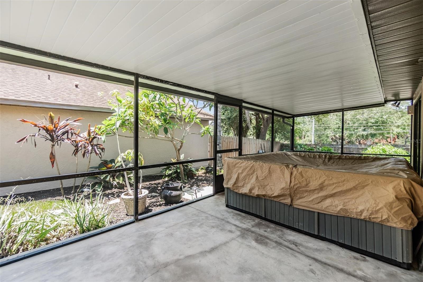 Screened-in patio with access from the 2nd bedroom and dining room large enough for table, seating, and spa.
