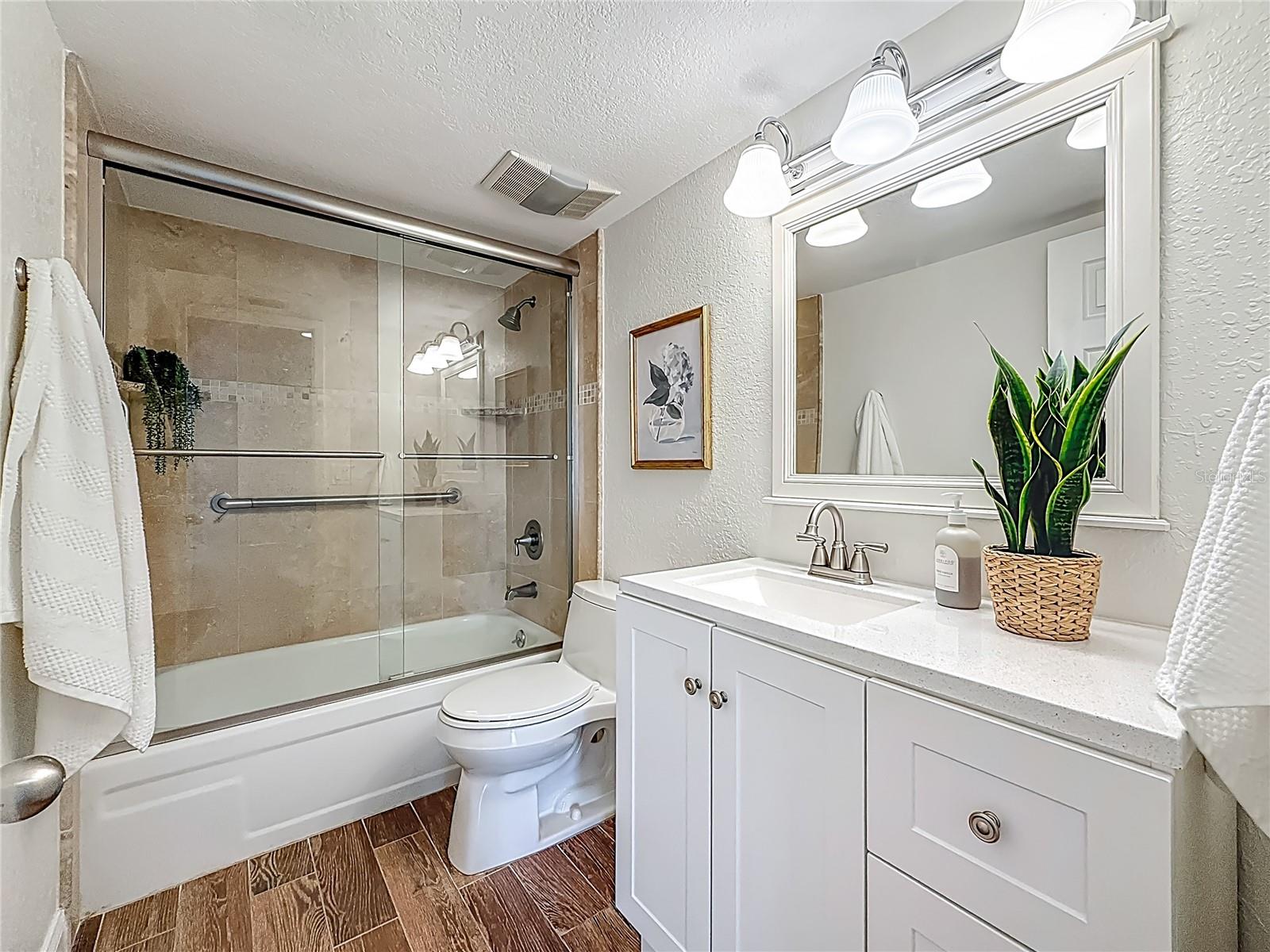 The 2nd bathroom has a glass enclosed tub and shower.
