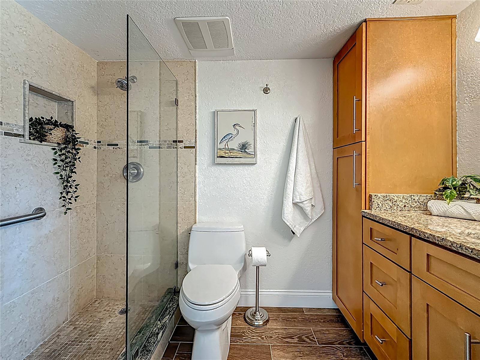 The ensuite bathroom has ample storage and a large walk-in shower.