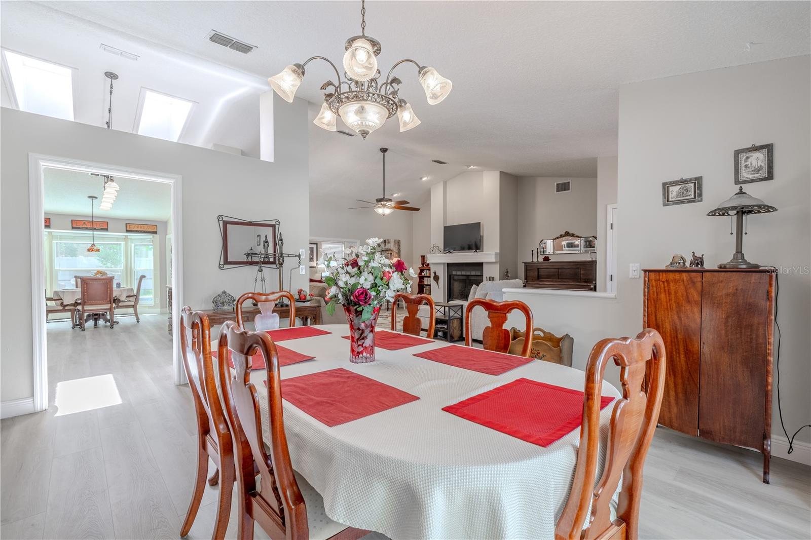 Centrally located just off the foyer and living room, this space enjoys easy access and a seamless flow for entertaining. A decorative chandelier adds a touch of traditional charm and elegance, while the room’s generous dimensions easily accommodate a full-size dining set.