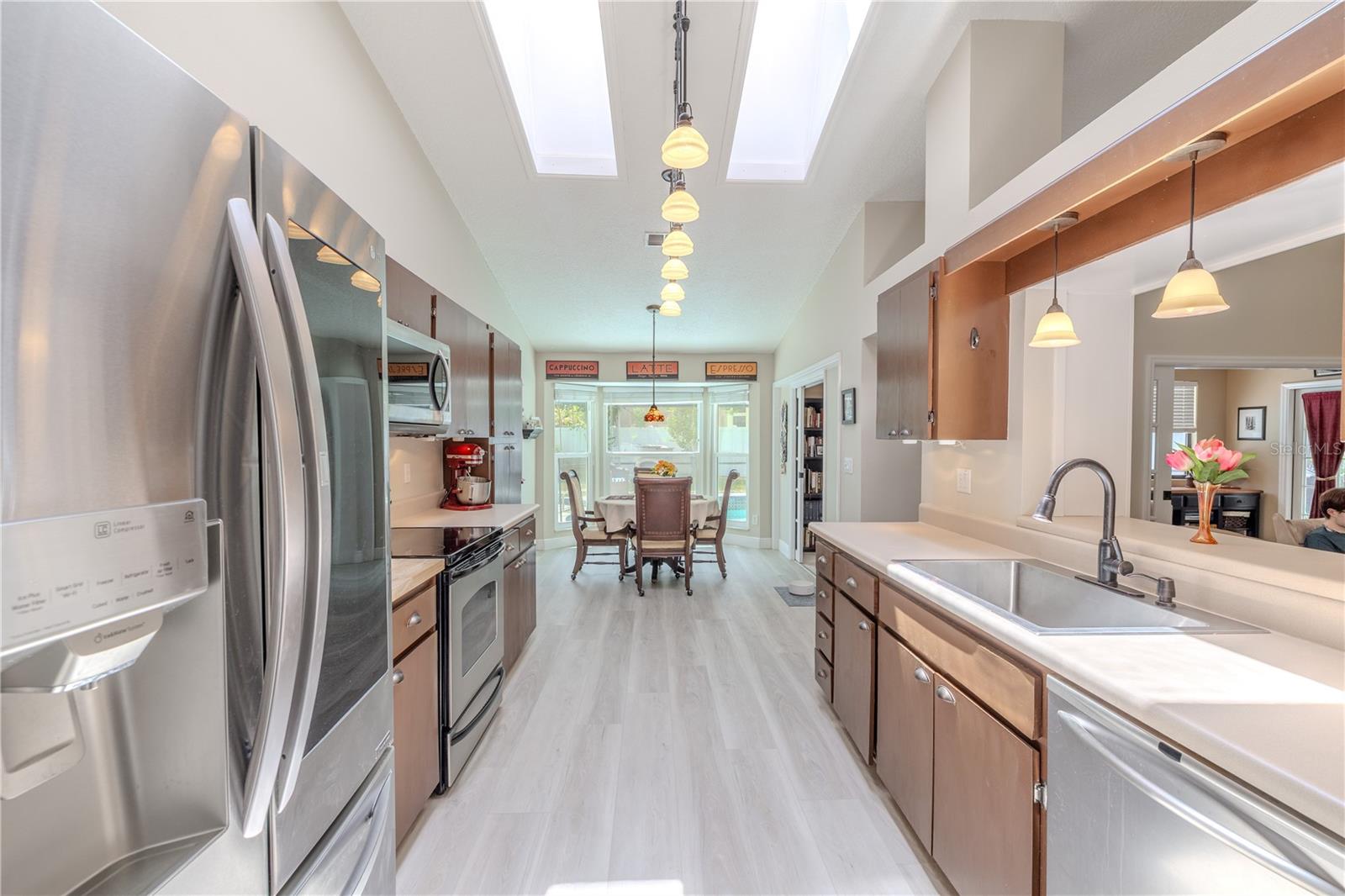 Equipped with stainless steel appliances, this kitchen offers ample cabinetry for storage, generous counter space, and a dedicated pantry wall to help keep everything organized. Luxury vinyl plank flooring (2025) continues through the space, offering durability and a modern look that ties beautifully into the rest of the home.