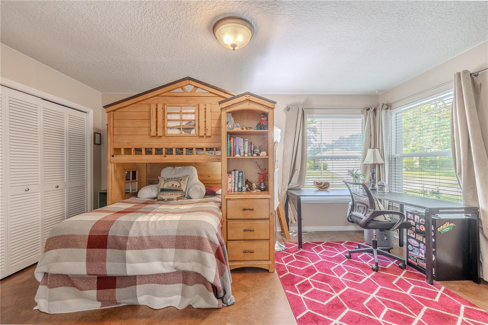 The second bedroom offers a bright and versatile space with ample natural light pouring in through double corner windows.