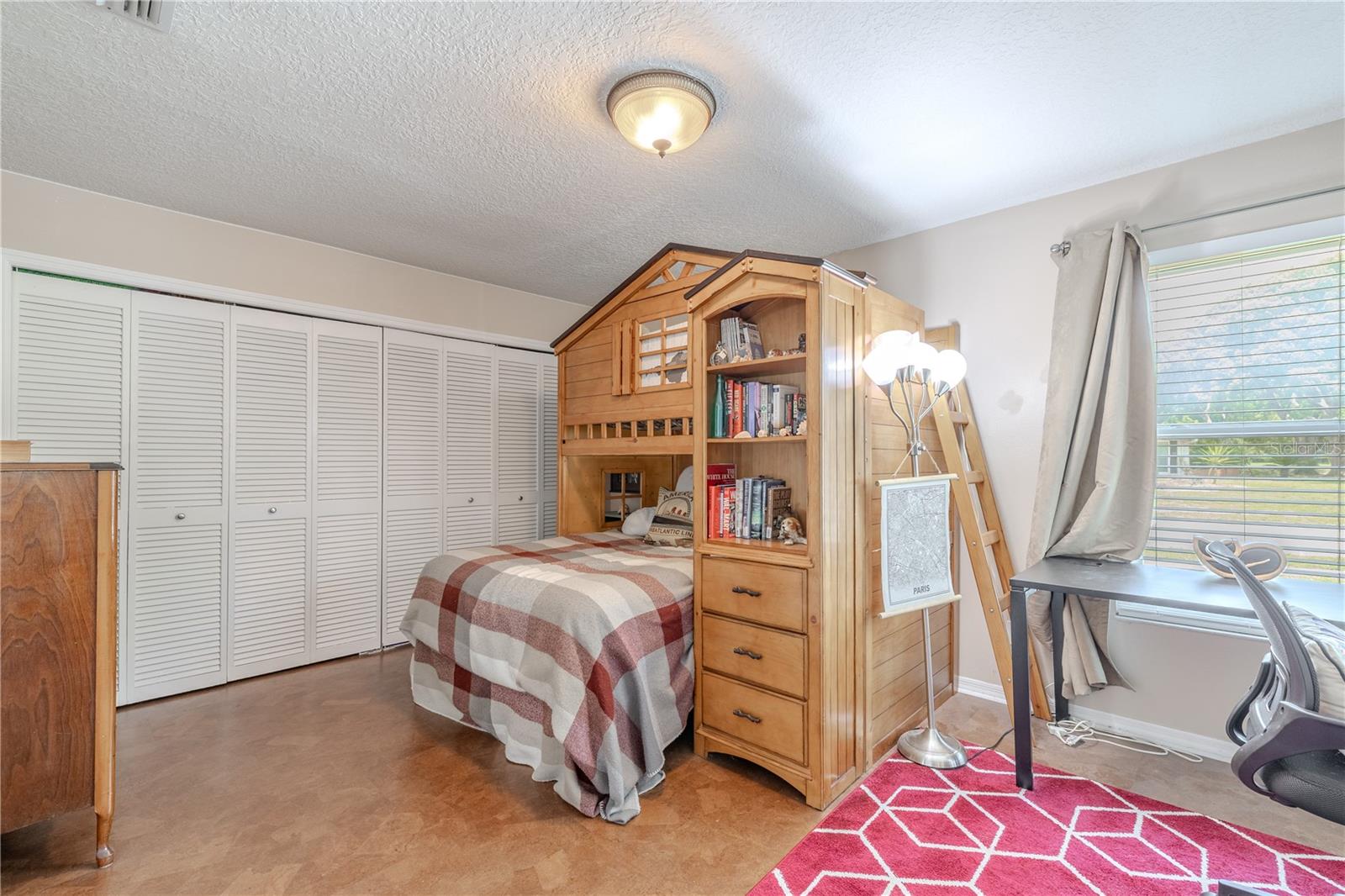 2nd bedroom" A full wall of louvered closet doors provides generous storage, while the room’s size allows for both sleeping and study zones.Whether it's playtime, homework, or rest, this cheerful bedroom is designed to grow with your needs and adds comfort and flexibility to the home’s layout.