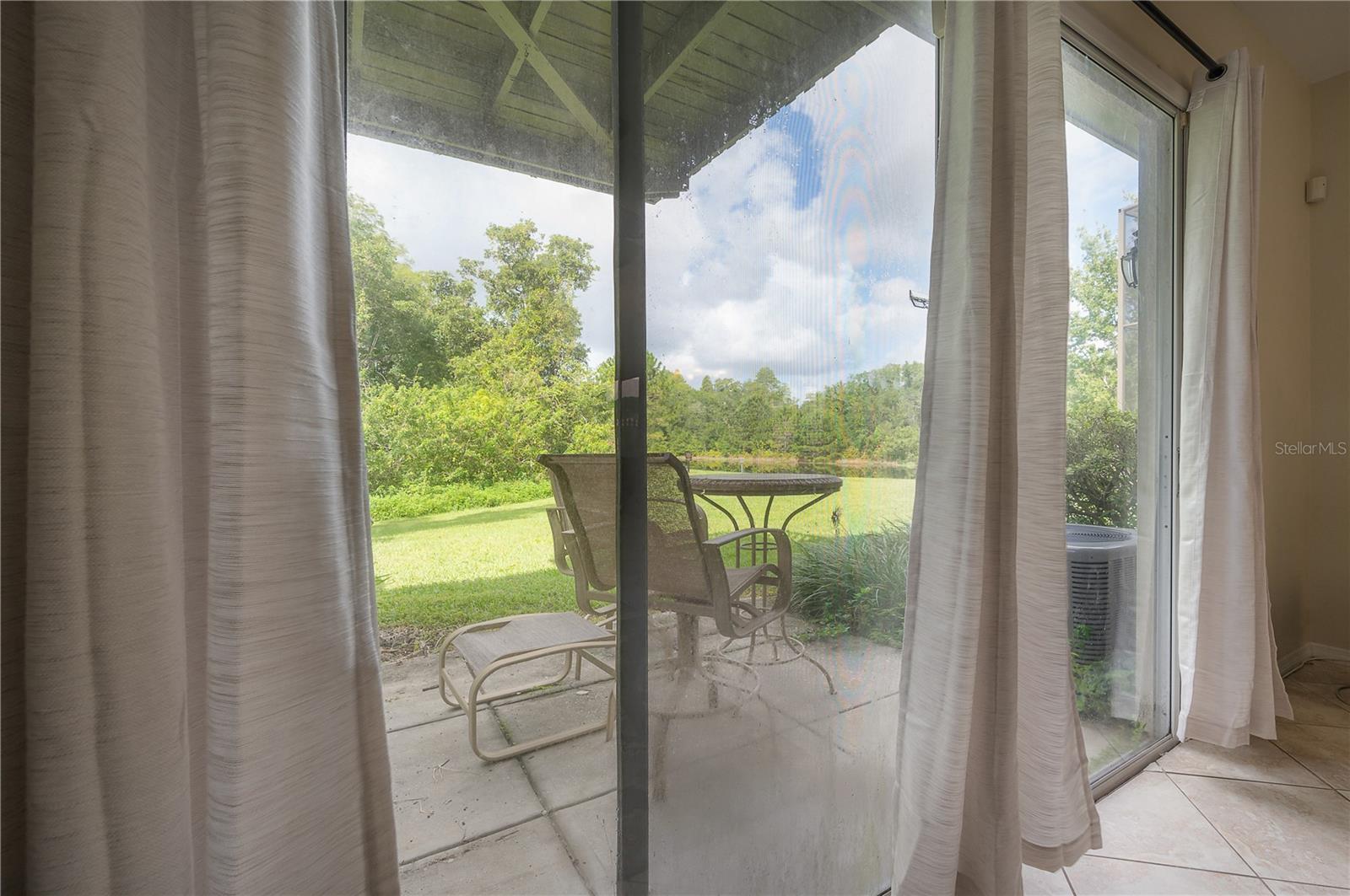 Family room looks out onto the conservation space a pond in the rear