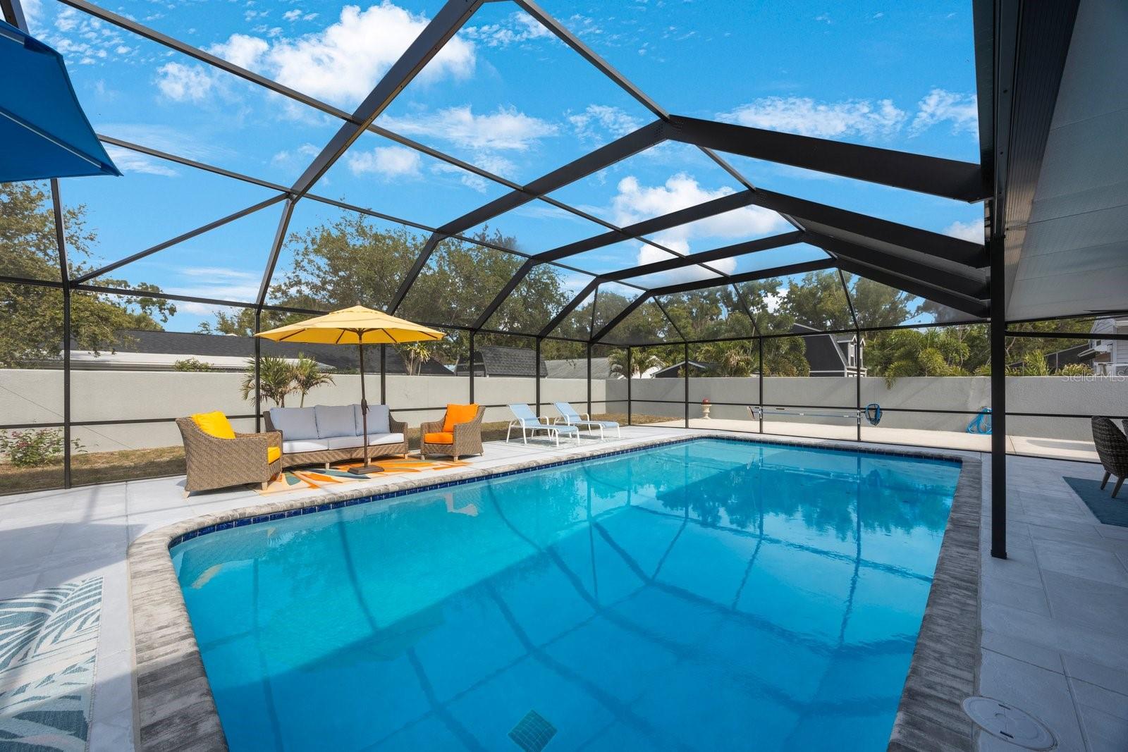 Your private Florida oasis awaits! Step into this expansive screened lanai and discover a sparkling pool, generous deck space for lounging, and the perfect setting for year-round outdoor relaxation and entertaining. Enjoy bug-free comfort in your own backyard paradise