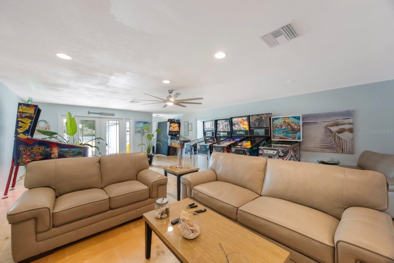 Discover the best of both worlds in this fantastic great room: a cozy corner perfect for unwinding, plus an incredibly spacious adjoining area. The current owners have transformed it into a spectacular pinball paradise (talk about a fun feature!), but this flexible zone is primed for your own vision. Whether you dream of a home theater, a play area, or keeping the good times rolling with your own collection, the space is here!